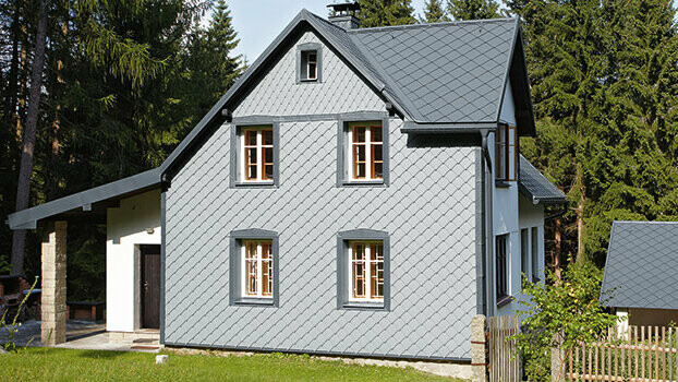 Rodinný dům s kompletním systémem PREFA; fasáda je obložena PREFA fasádními šablonami 29x29 ve světle šedé barvě.