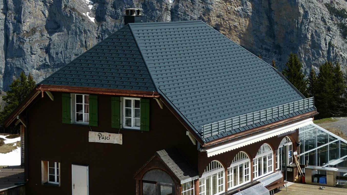 Sanace střechy horské chaty s polovalbovou střechou za použití PREFA falcovaných střešních šindelů se sněhovými zarážkami