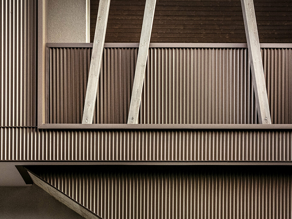 Detail zubaté hliníkové fasády se šikmými dřevěnými trámy vily 2B v Morbegno rekonstruované podle návrhu architekta Massima Mescia z altrostudio architetti.
