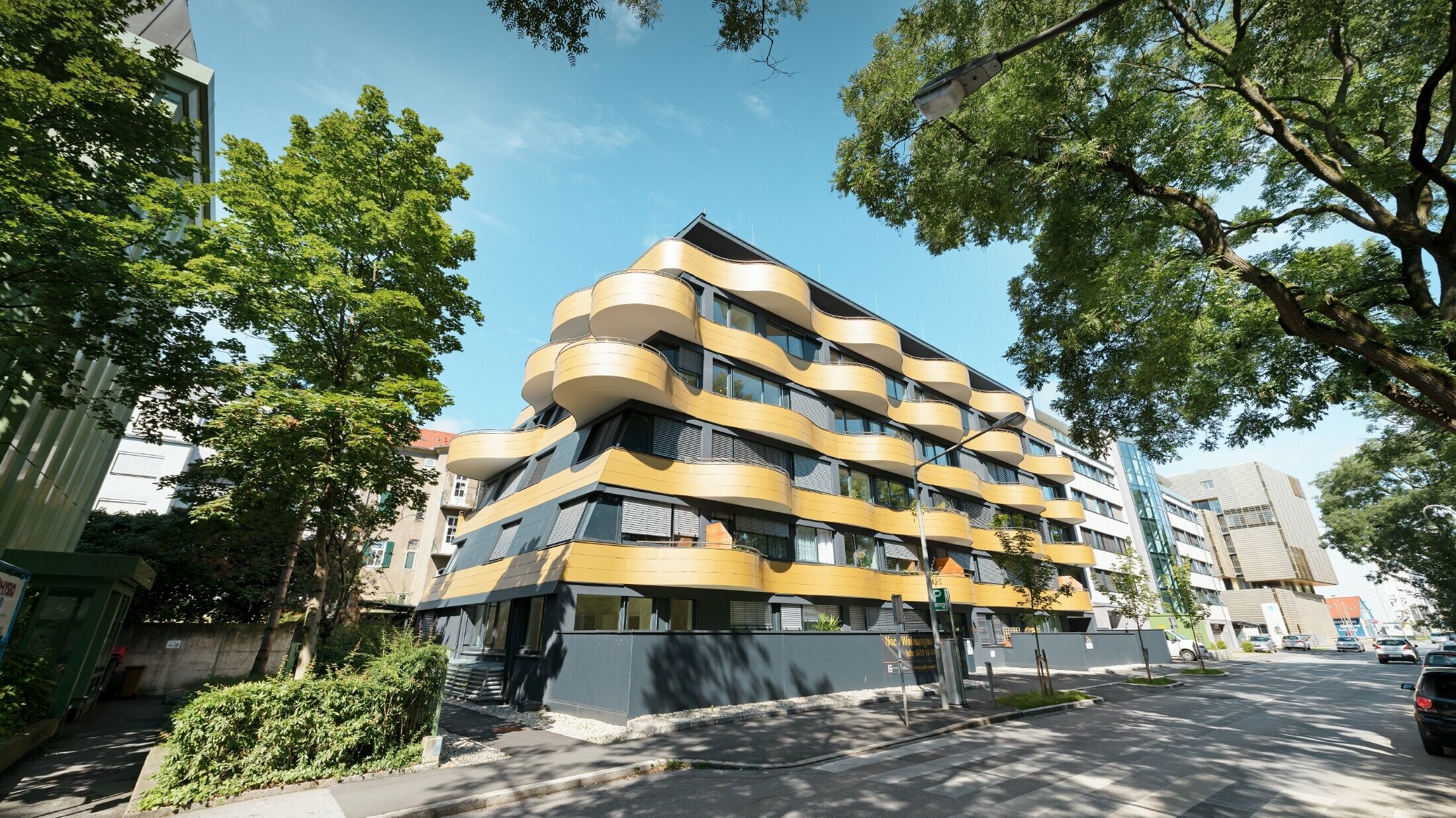 Obytný komplex "Golden Wave" neboli zlatá vlna v rakouském Grazu s hliníkovou kompozitní deskou PREFABOND ve zlaté barvě. Balkony zde byly zaobleny do vln.