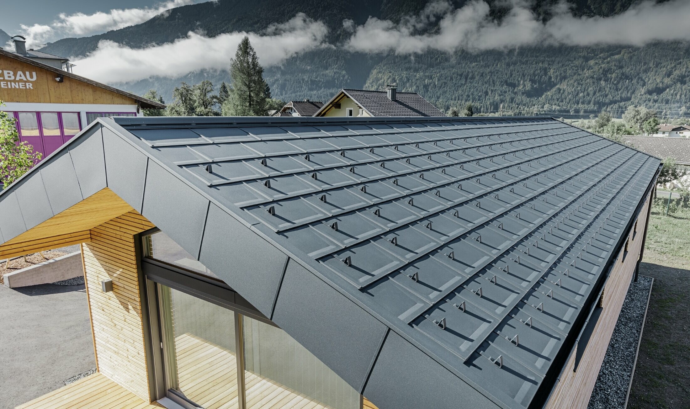 Sedlová střecha pokrytá střešními panely R.16 a svitkovými plechem PREFALZ v barvě P.10 antracitové 