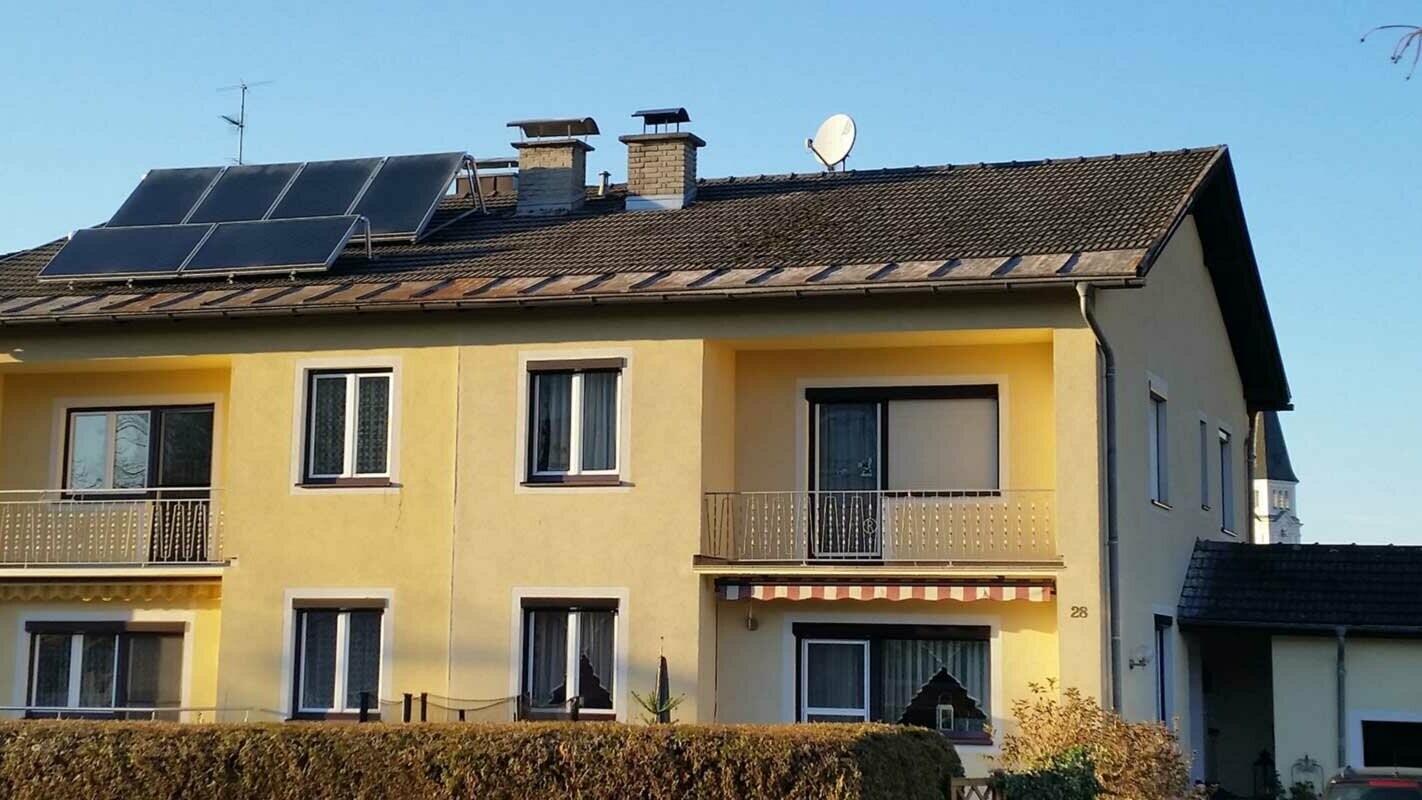 Bytový dům v Rakousku před sanací střechy za použití PREFA falcovaných střešních tašek 