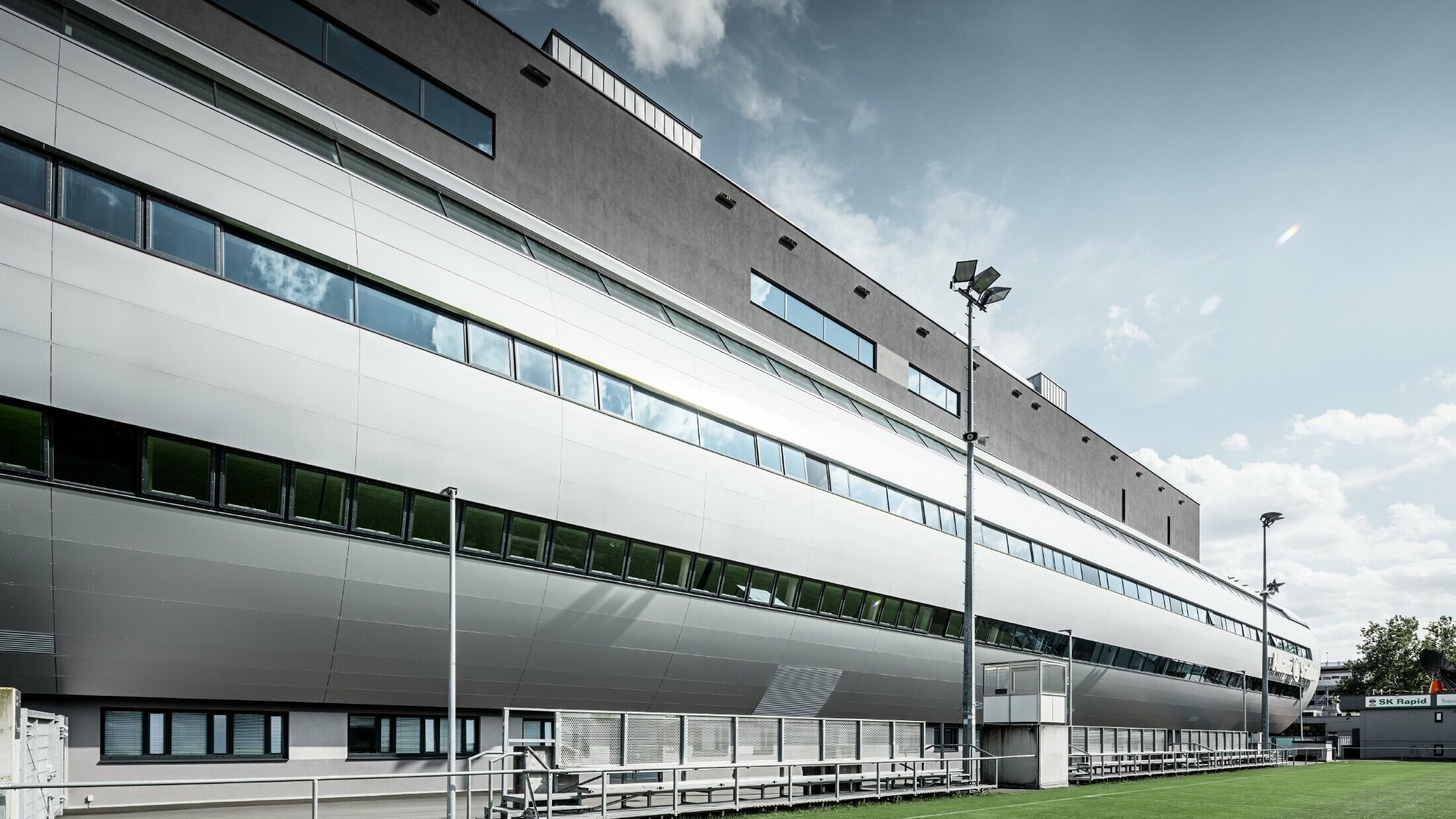 Pohled na stadion Allianz ve Vídni z tréninkového hřiště. Tubus vede do útrob stadionu je pokryt hliníkovým kompozitním panelem PREFABOND ve stříbrné metalíze.