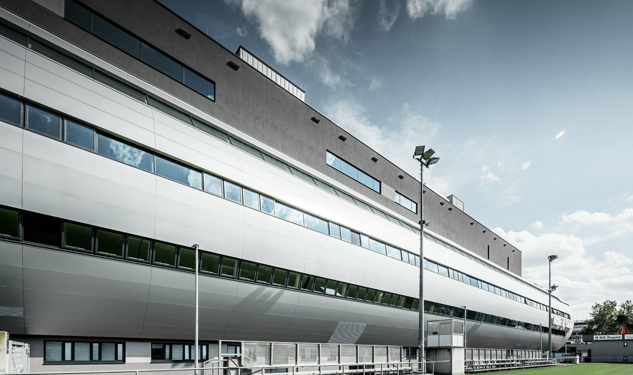 Pohled na stadion Allianz ve Vídni z tréninkového hřiště. Tubus vede do útrob stadionu je pokryt hliníkovým kompozitním panelem PREFABOND ve stříbrné metalíze.