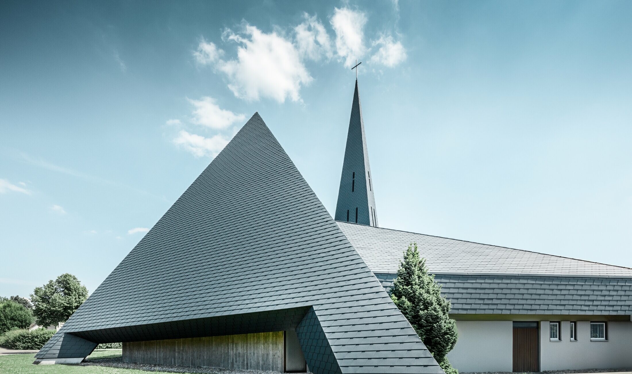 Katolický kostel v Langenau s designem podobným pyramidě pokrytý hliníkovým šindelem PREFA v antracitové barvě