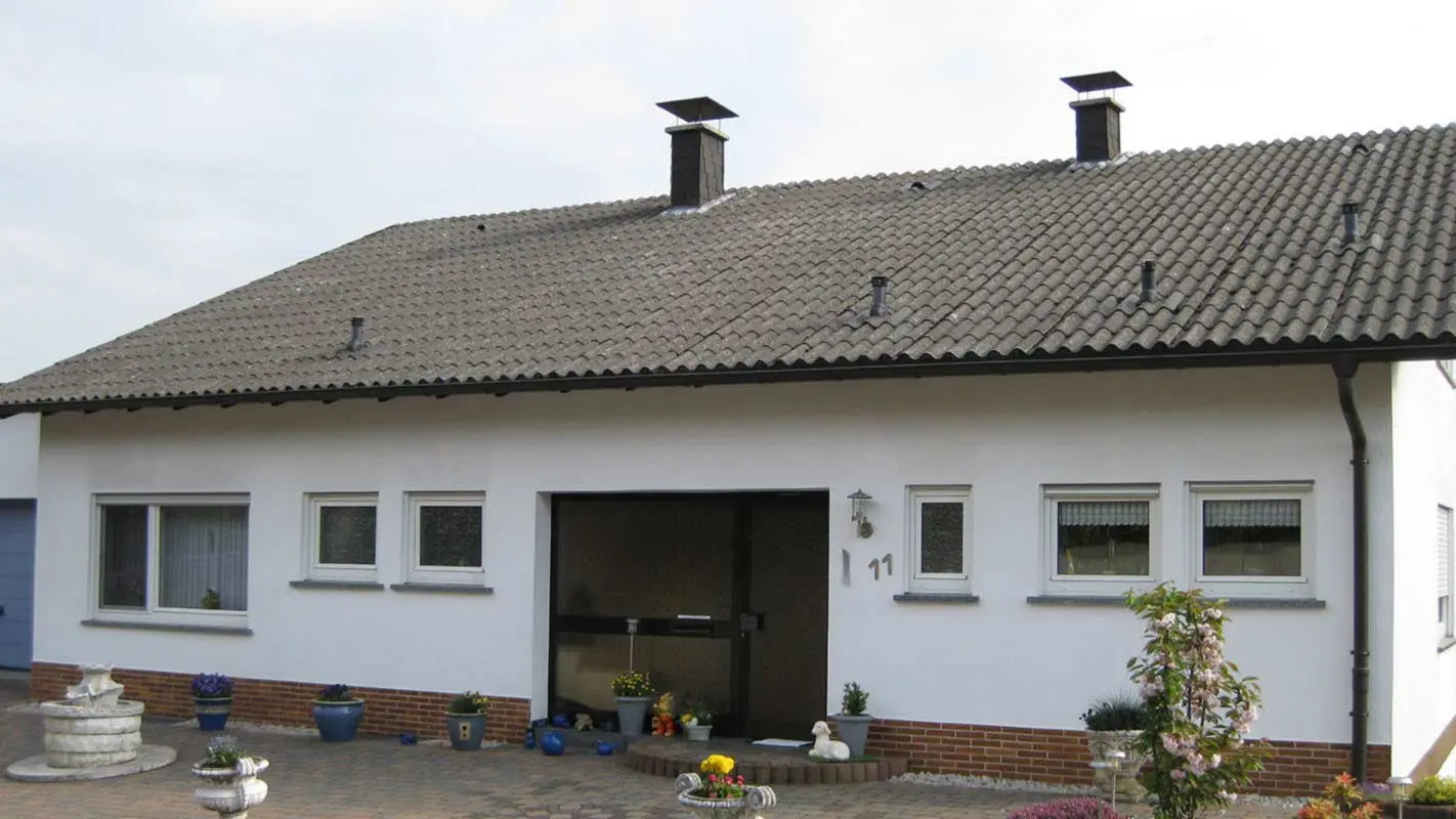 Rodinný dům před sanací střechy s původní vlnitou osinkocementovou krytinou  za použití PREFA falcovaných střešních tašek 