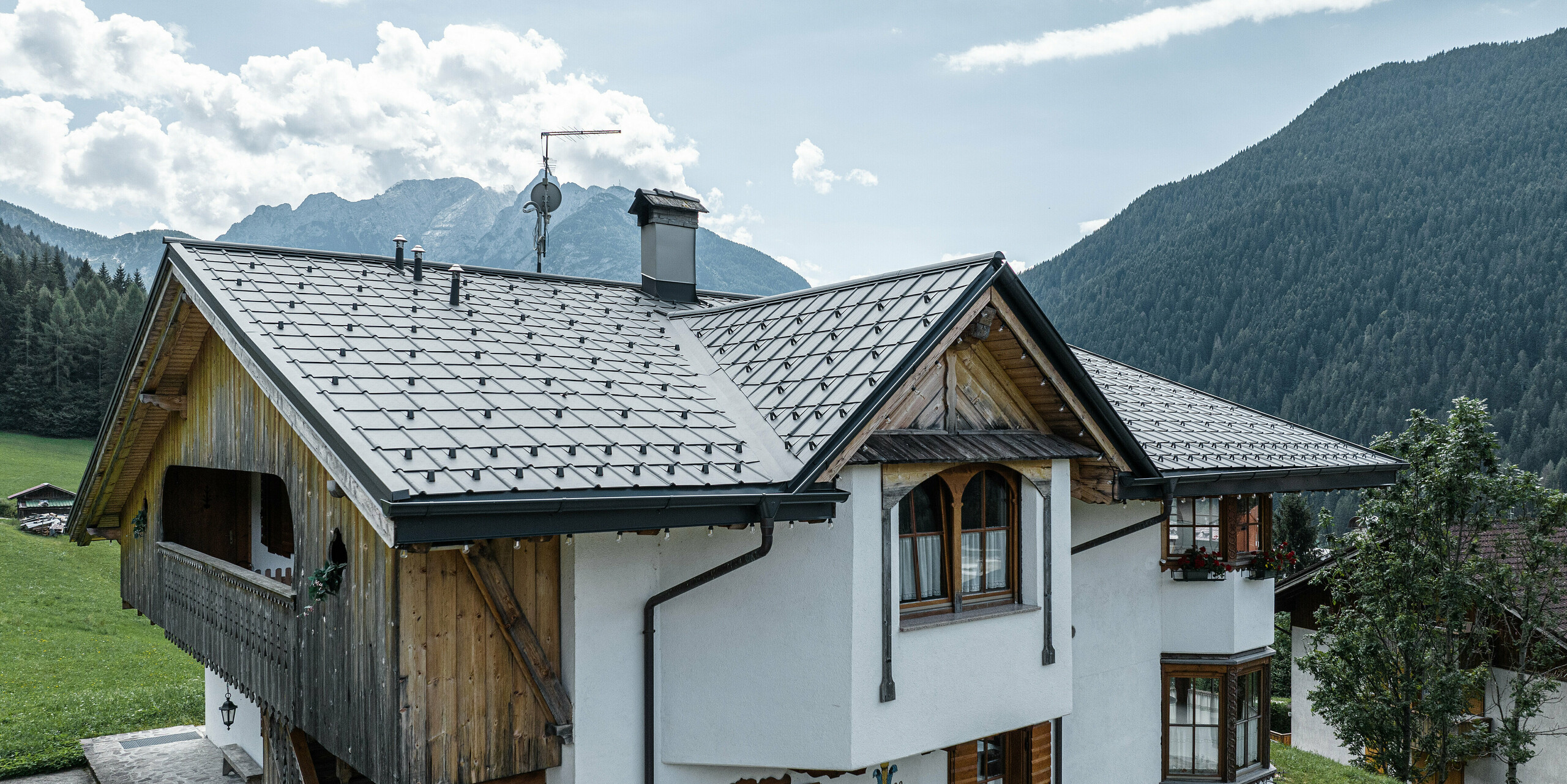 Horská chata v Auronzo di Cadore v Itálii s čerstvě zrekonstruovanou střechou ze světle šedých falcovaných tašek PREFA, které spojují tradici a modernost. Pečlivá obnova zachovává okouzlující detaily, jako jsou dřevěné balkony a řezbářské práce, a zároveň chrání budovu pomocí odolné hliníkové střechy nenáročné na údržbu, která zapadá do přírodní horské krajiny.