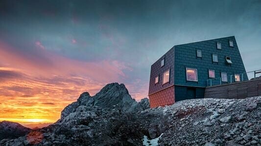 Výjimečná architektura na horách: horská chata Seethalerhütte na Dachsteinu je opláštěná střešním a fasádním panelem PREFA FX.12 v barvě P.10 břidlicové. 
