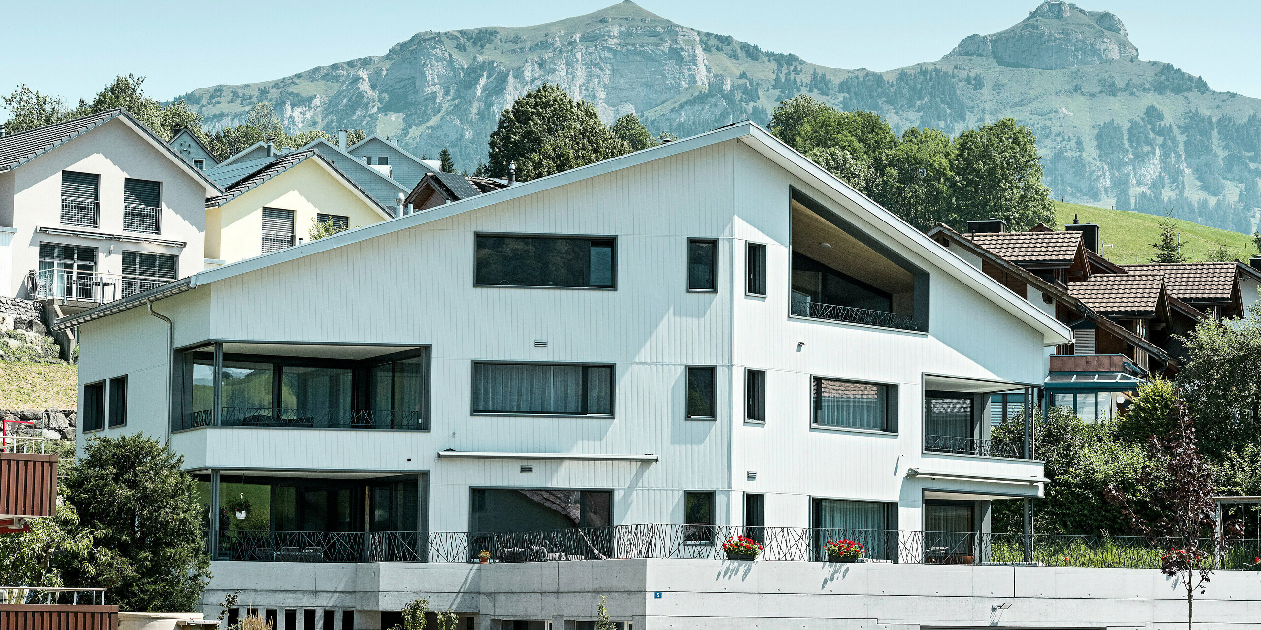 Čelní pohled na bytový dům opláštěný fasádními lamelami Siding v barvě P.10 prefa bílé