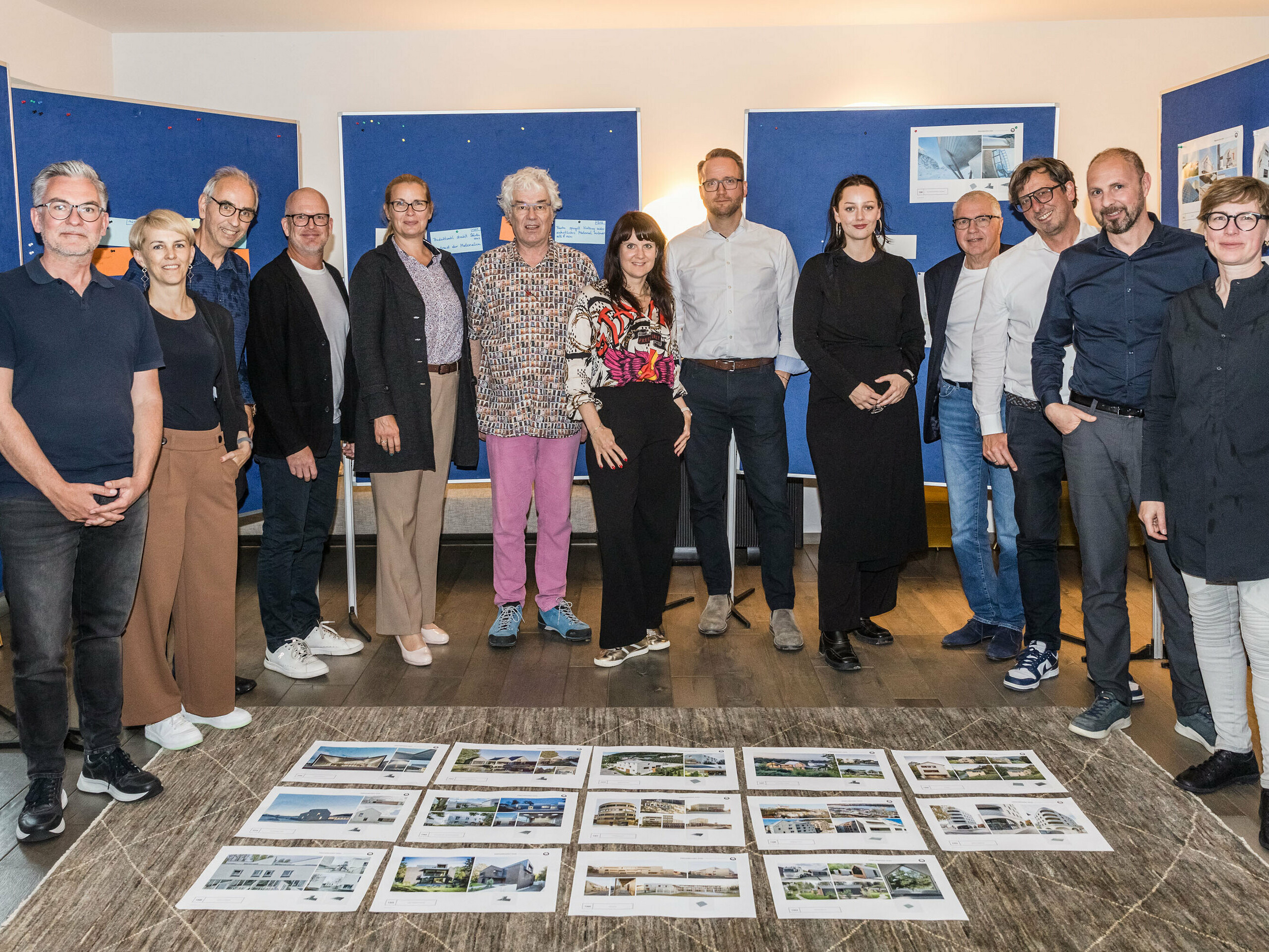 Společná fotografie poroty PREFARENZEN 2026 po úspěšném výběrovém řízení ve vinařském sídle v regionu Seewinkel v Burgenlandu: Interdisciplinární skupina expertů ve složení Dirk Lorenz (Leinert Lorenz Architects), Veronika Roll (marketing, PREFA Rakousko), Wolfgang Croce (Croce & Wir, Graz), Jürgen Jungmair (manažer mezinárodního marketingu, PREFA), Judit Nemere (jednatelka PREFA Maďarsko), Matthias Finkentey (moderování), Bettina Almeida (komunikační management, PREFA), Christian Wirth (regionální manažer pro východ, PREFA Rakousko), Selina Wach (vedoucí diskurzu, Architektur Aktuell), Thomas Schlett (B3 Architects), Sven Disser (vedoucí rozvoje, Bauwerk), Falk Leinert (Leinert Lorenz Architects) a Juliane Croce (Croce & Wir, Graz) stojí před konečně vybranými architektonickými projekty pro Architektonickou knihu a kalendář PREFARENZEN 2026. Projekty odrážejí rozmanitost, udržitelnost a inovativní využití materiálů PREFA.