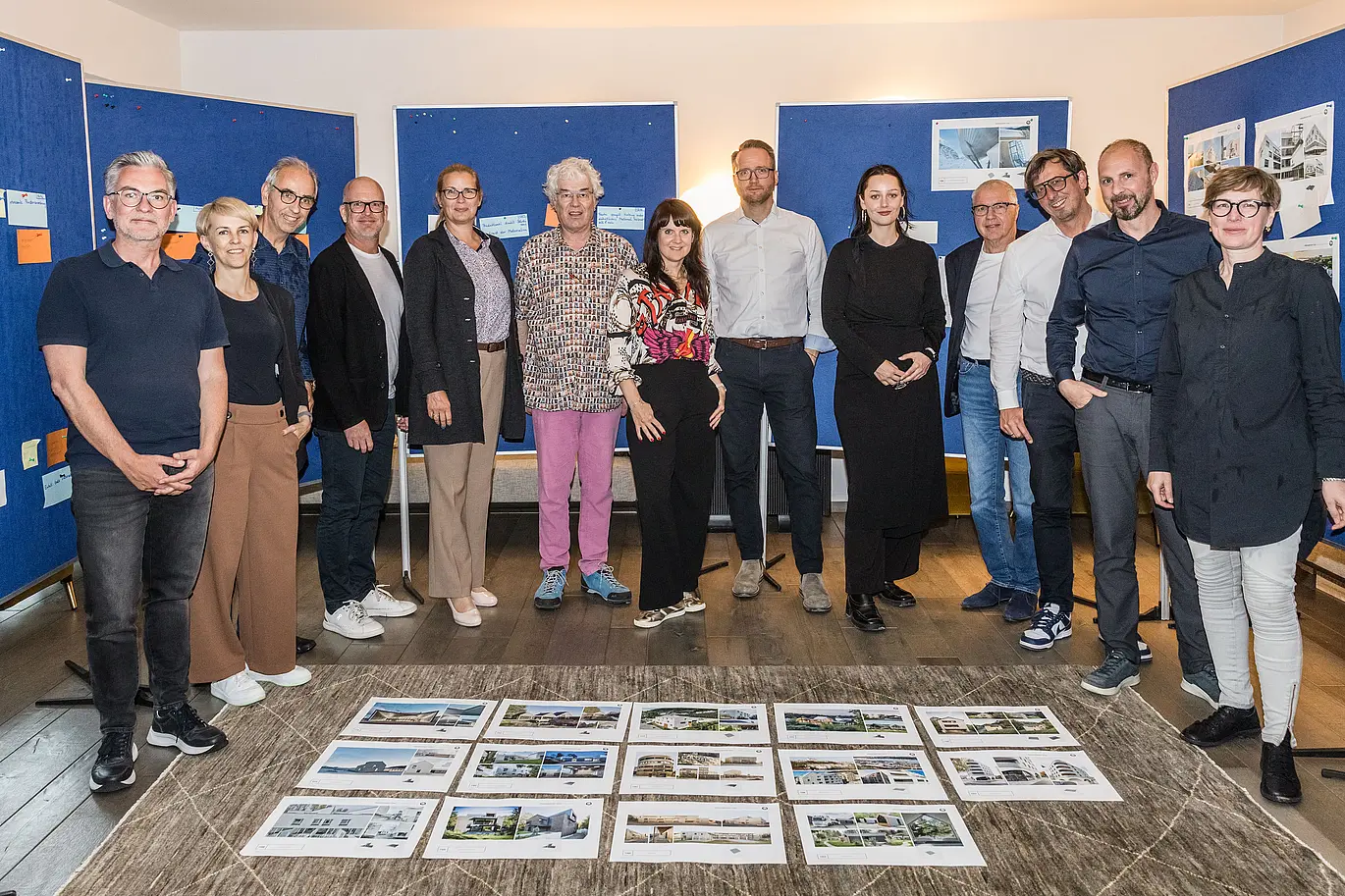Společná fotografie poroty PREFARENZEN 2026 po úspěšném výběrovém řízení ve vinařském sídle v regionu Seewinkel v Burgenlandu: Interdisciplinární skupina expertů ve složení Dirk Lorenz (Leinert Lorenz Architects), Veronika Roll (marketing, PREFA Rakousko), Wolfgang Croce (Croce & Wir, Graz), Jürgen Jungmair (manažer mezinárodního marketingu, PREFA), Judit Nemere (jednatelka PREFA Maďarsko), Matthias Finkentey (moderování), Bettina Almeida (komunikační management, PREFA), Christian Wirth (regionální manažer pro východ, PREFA Rakousko), Selina Wach (vedoucí diskurzu, Architektur Aktuell), Thomas Schlett (B3 Architects), Sven Disser (vedoucí rozvoje, Bauwerk), Falk Leinert (Leinert Lorenz Architects) a Juliane Croce (Croce & Wir, Graz) stojí před konečně vybranými architektonickými projekty pro Architektonickou knihu a kalendář PREFARENZEN 2026. Projekty odrážejí rozmanitost, udržitelnost a inovativní využití materiálů PREFA.