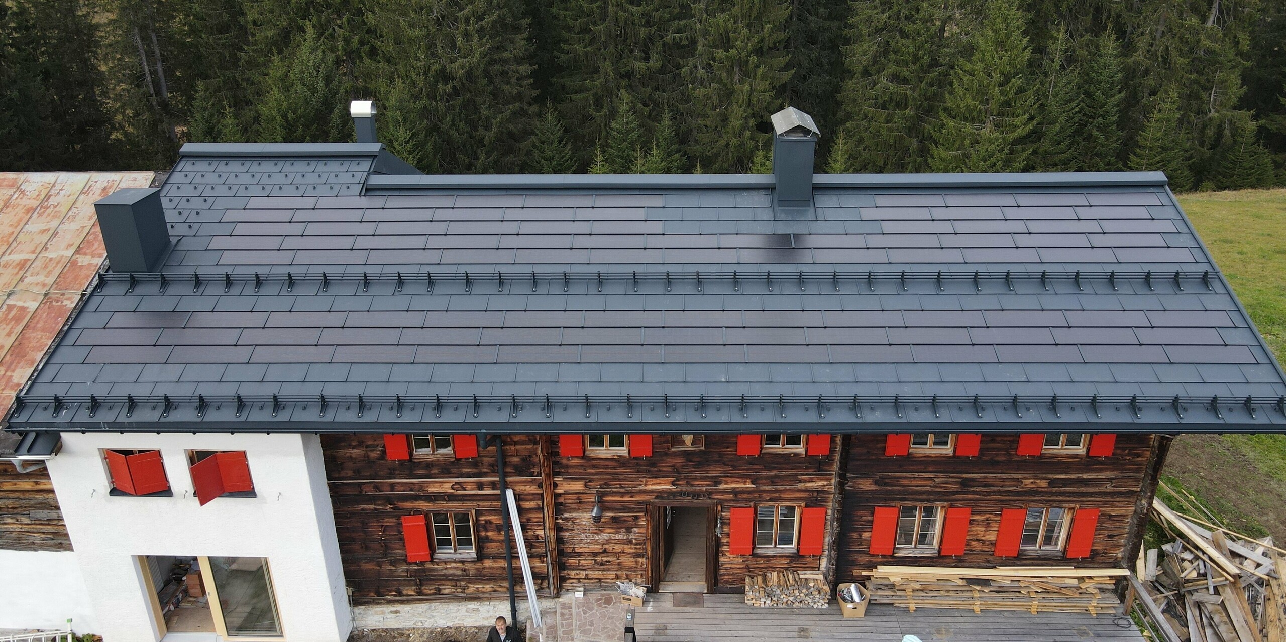 Solární střešní panel PREFA v barvě P.10 antracit na starém domě ve Warthu v Vorarlbersku
