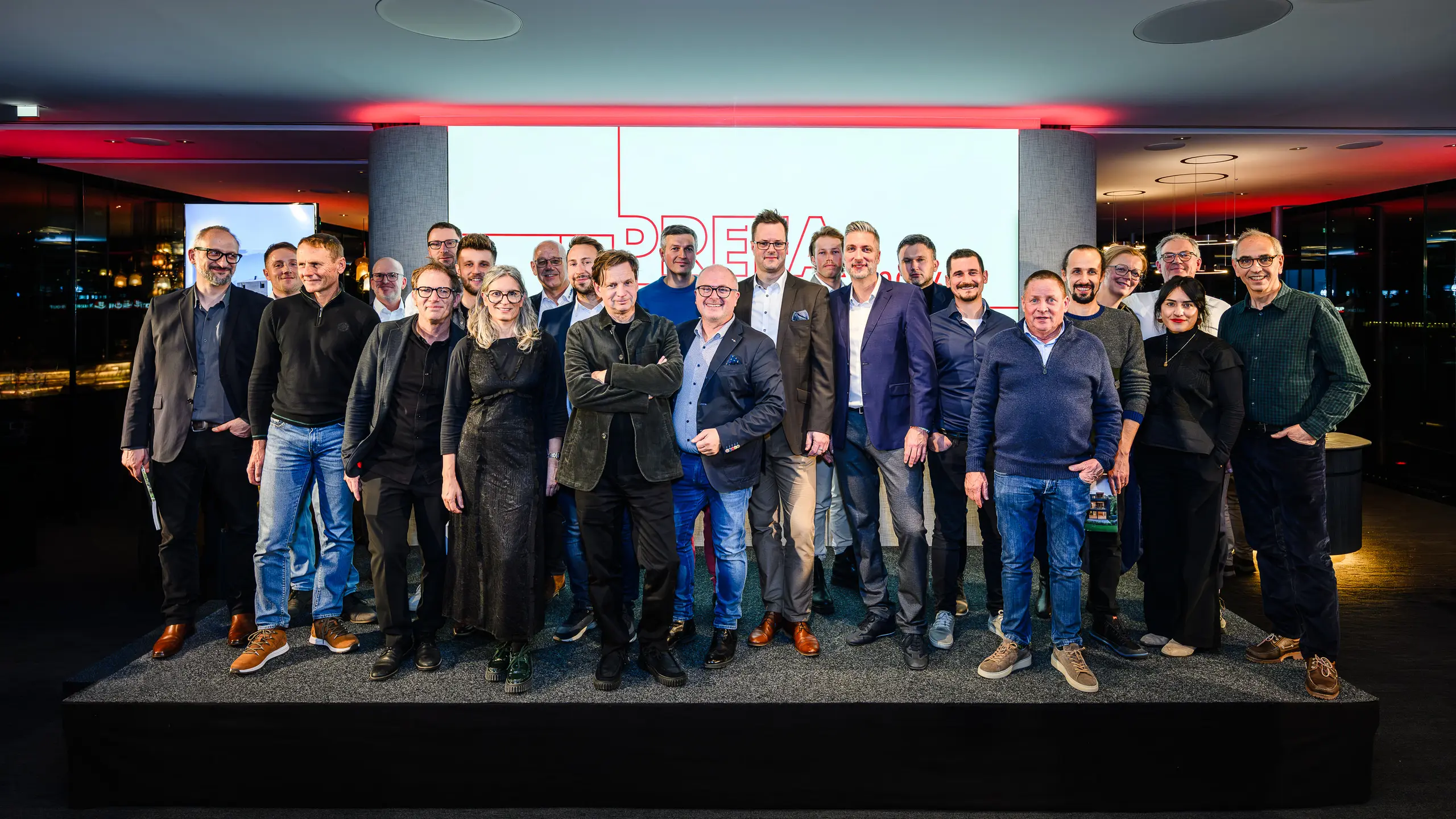 Společná fotografie architektů, projektantů a dodavatelů na pódiu prezentace PREFARENZEN 2026 v k47.wien – silného symbolu komunity, kreativity a progresivní architektury. Před osvětleným logem PREFARENZEN stojí designéři stojící za působivými projekty s hliníkem PREFA. Scéna odráží hrdost, inovaci a spolupráci. Produkty PREFA nabízejí trvanlivá, povětrnostně odolná řešení s estetickým vzhledem – ideální pro moderní architektonické koncepty. Inspirativní večer plný výměny názorů, vizí a silných partnerství.