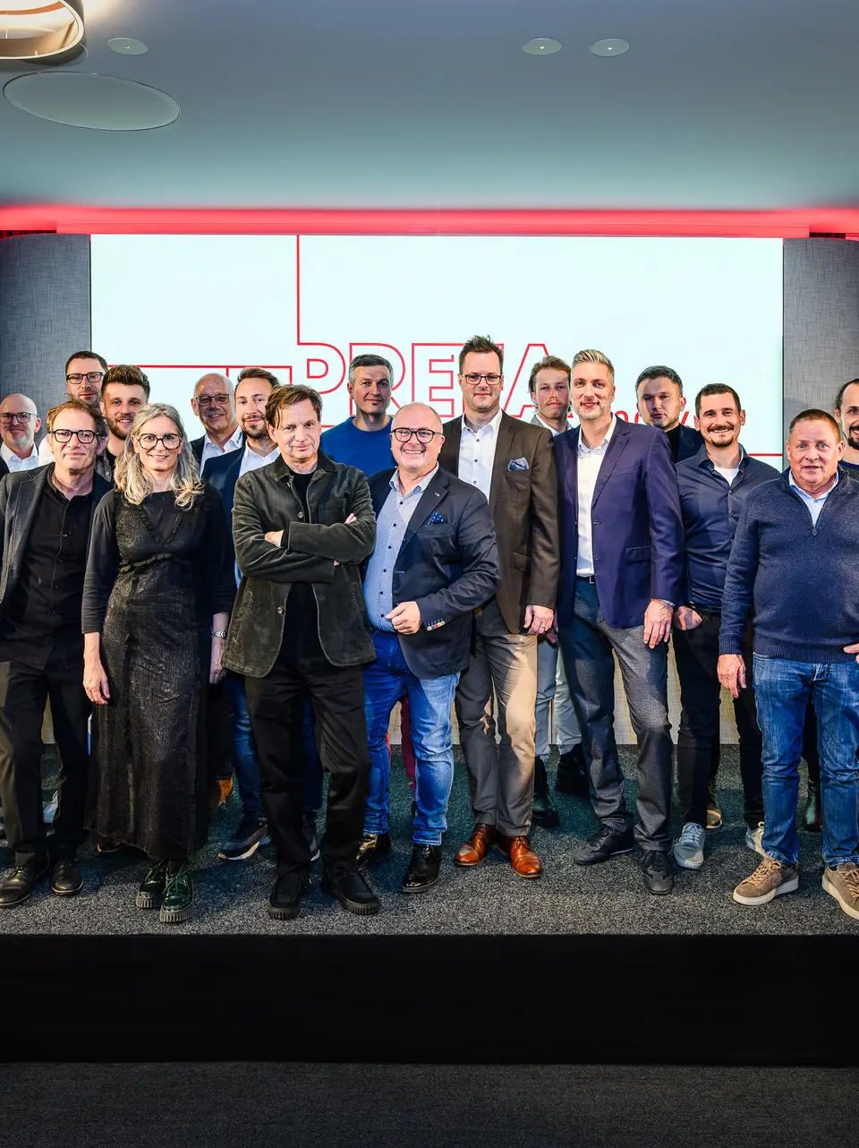 Společná fotografie architektů, projektantů a dodavatelů na pódiu prezentace PREFARENZEN 2026 v k47.wien – silného symbolu komunity, kreativity a progresivní architektury. Před osvětleným logem PREFARENZEN stojí designéři stojící za působivými projekty s hliníkem PREFA. Scéna odráží hrdost, inovaci a spolupráci. Produkty PREFA nabízejí trvanlivá, povětrnostně odolná řešení s estetickým vzhledem – ideální pro moderní architektonické koncepty. Inspirativní večer plný výměny názorů, vizí a silných partnerství.