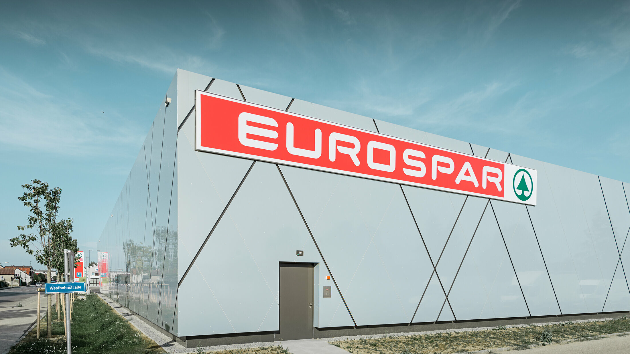 Zadní strana nové pobočky Eurospar ve Walesu. fasáda byla opláštěna hliníkovými kompozitními deskami PREFABOND v unikátní barvě stříbrně-zlaté.