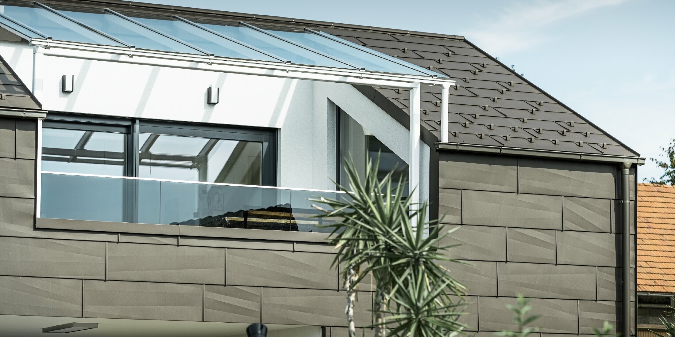 Přístavba kompletně opláštěná systémem PREFA, střechu a fasádu pokrývají střešní a fasádní panely FX.12 v barvě P.10 tmavě hnědé