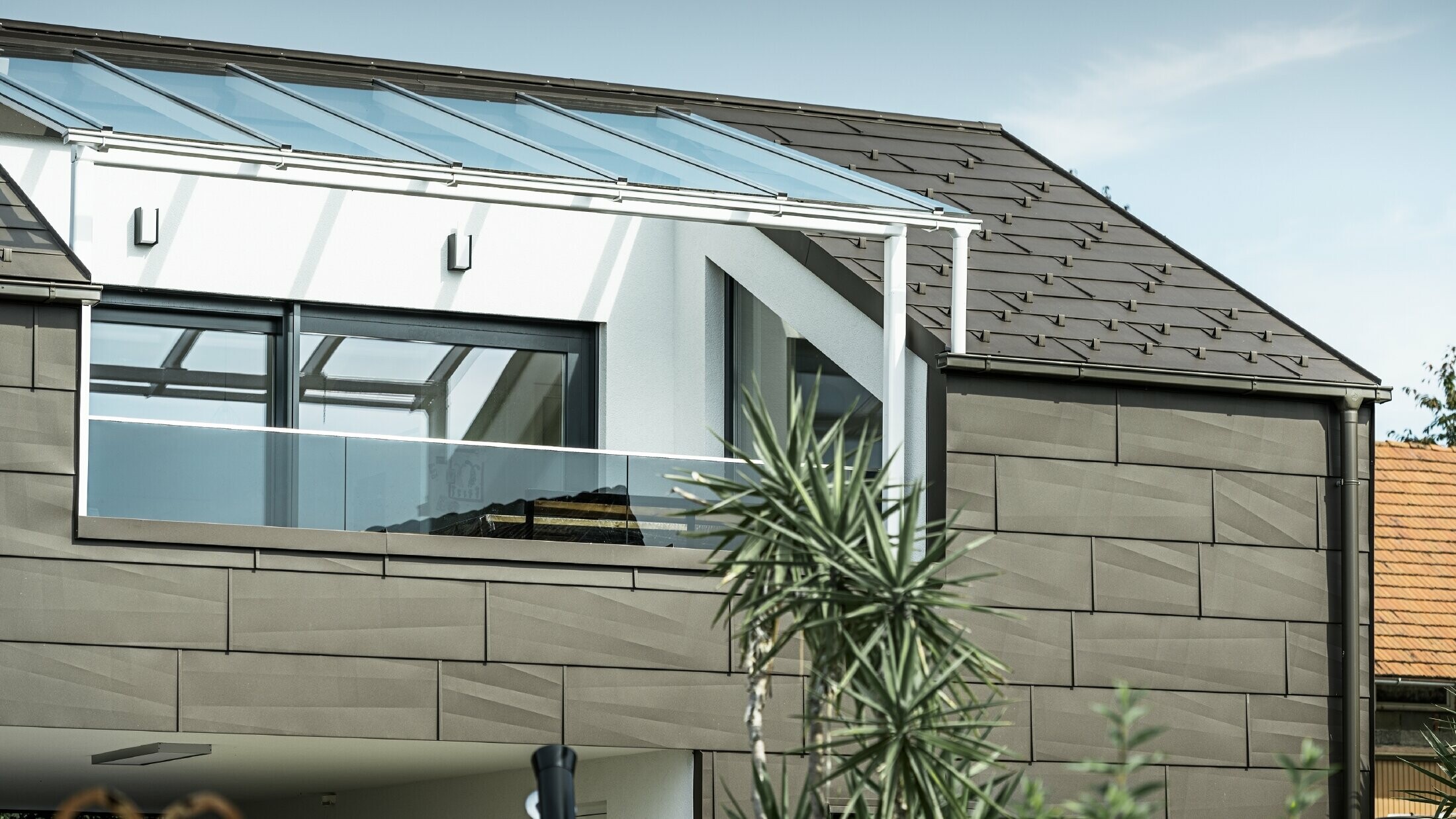 Přístavba kompletně opláštěná systémem PREFA, střechu a fasádu pokrývají střešní a fasádní panely FX.12 v barvě P.10 tmavě hnědé