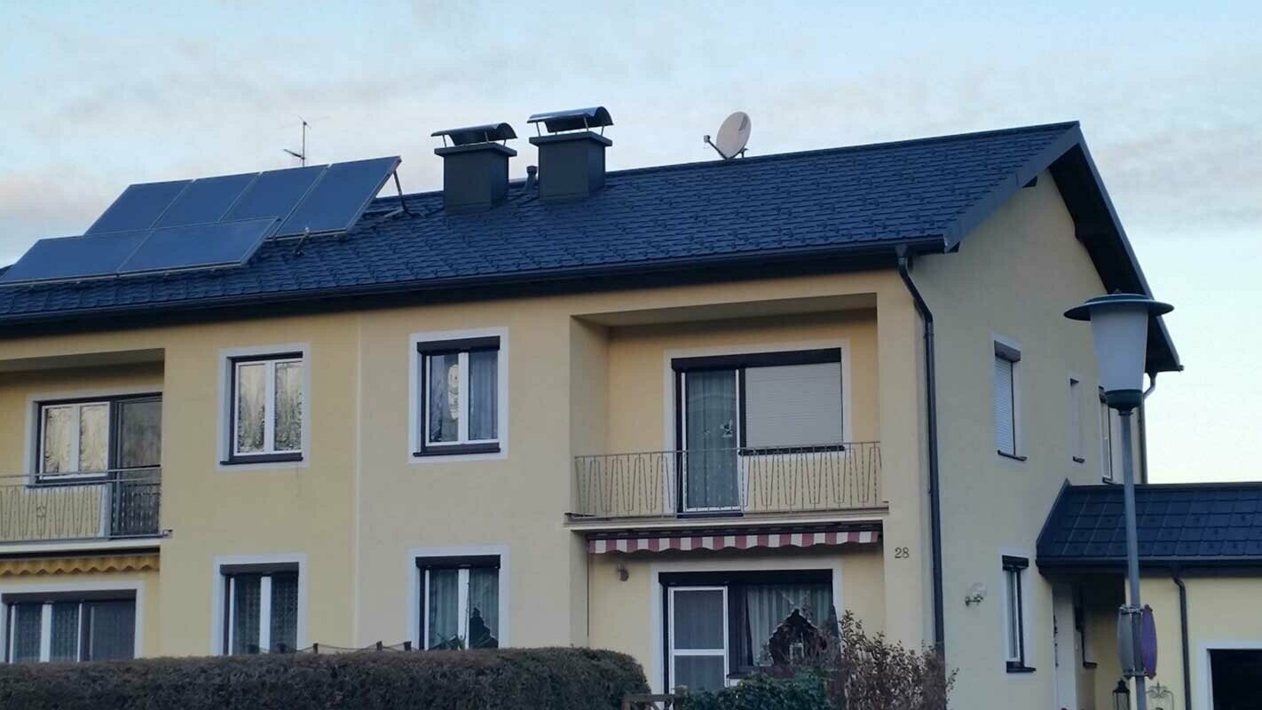 Bytový dům v Rakousku po sanaci střechy za použití PREFA falcovaných střešních tašek 
