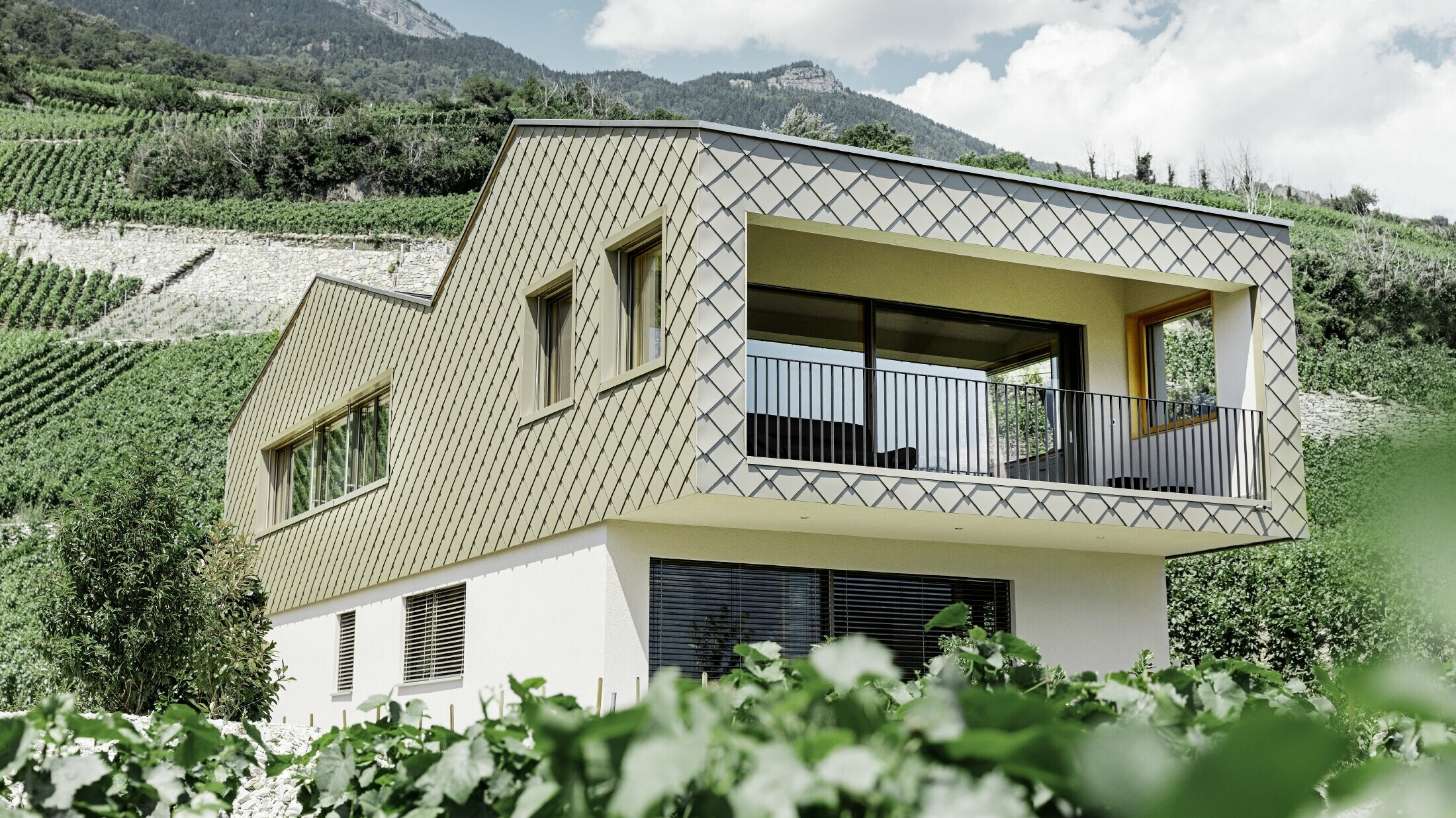 modernes Einfamilienhaus mitten in den Weinbergen des Rhônetals mit 4 unterschiedlichen Dachflächen und offener Galerie mit einer Rautenfassade in bronze