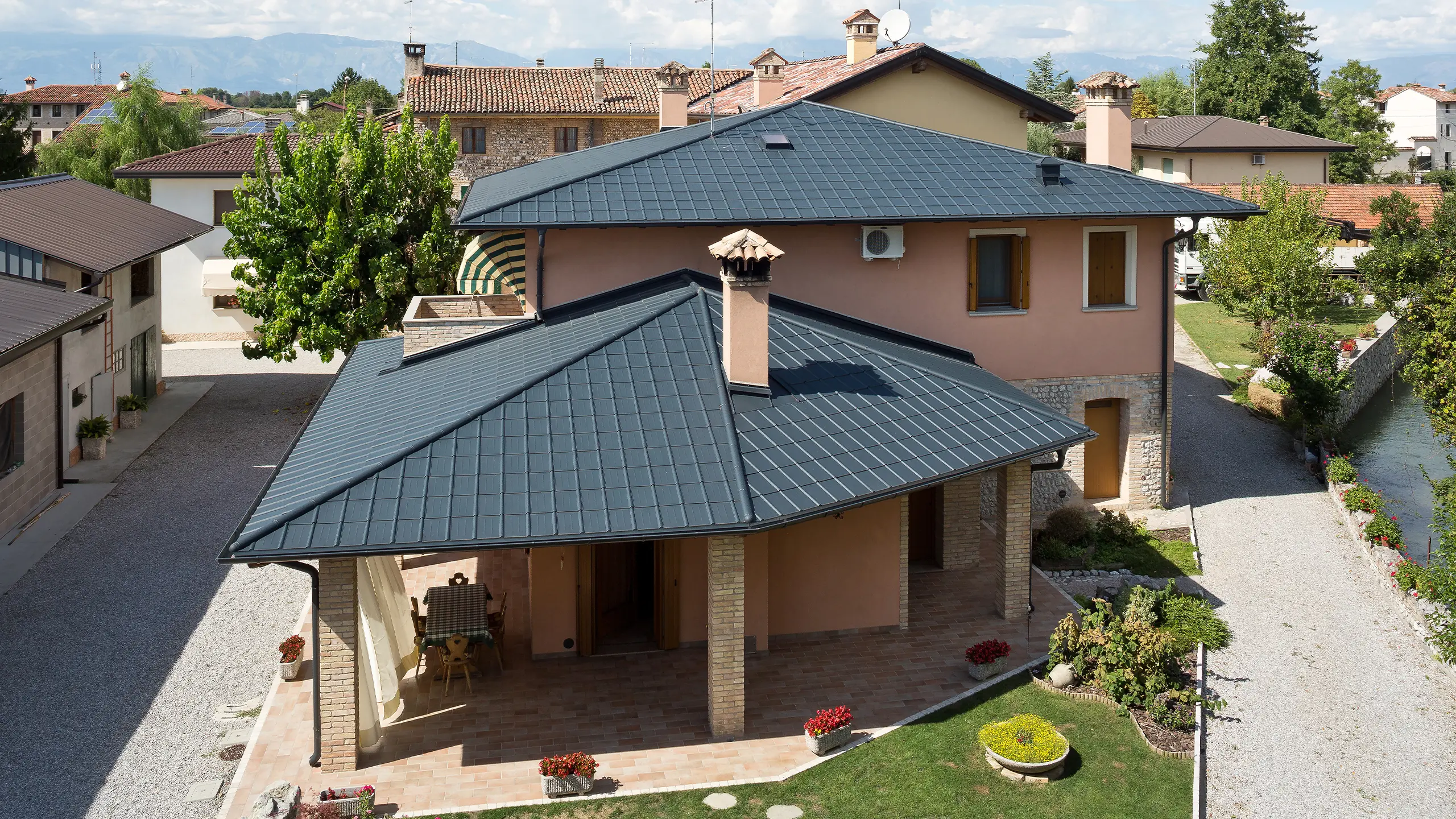 Italská vila s typickou stanovou střechou se falcovanou taškou PREFA v antracitové barvě P.10