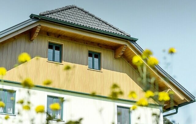Giebelverkleidung mit den Alu Paneelen von PREFA in Holzoptik Eiche natur, verarbeitet sind die Sidings in vertikal inklusive Verkleidung der Dachuntersicht