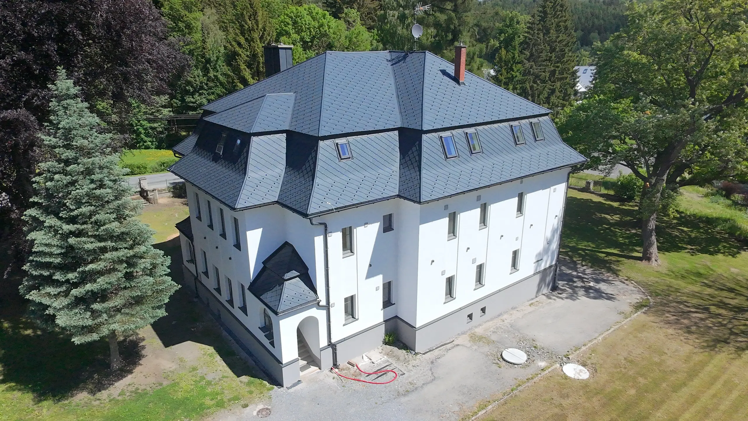 Pohled z ptačí pespektivy na zámeček s PREFA falcovanými šablonami 44x44 a 29x29