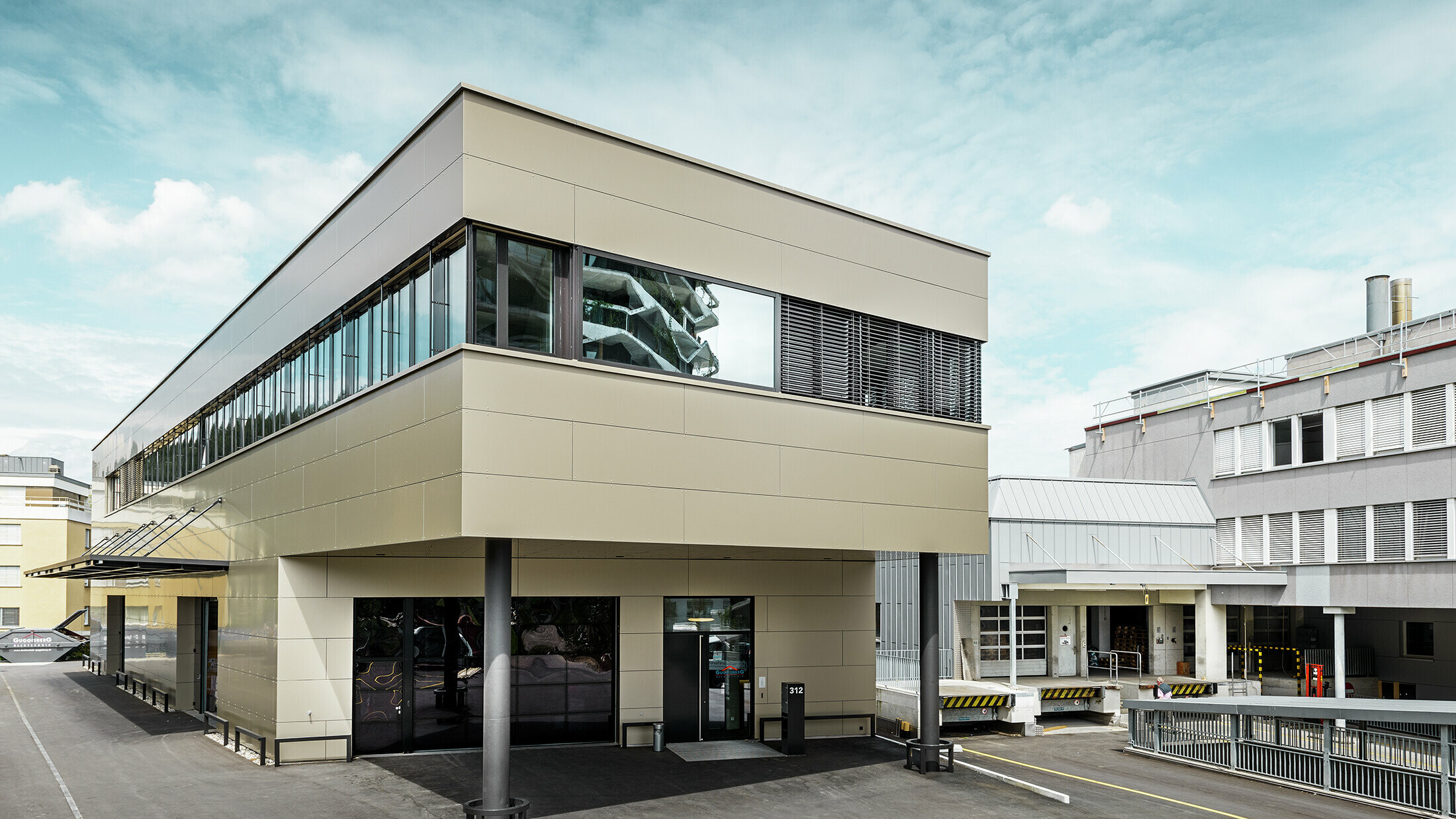 Moderní přístavba s dílnou a kanceláří od Guggisberg Dachtechnik s hliníkovými kompozitními deskami PREFABOND v bronzu