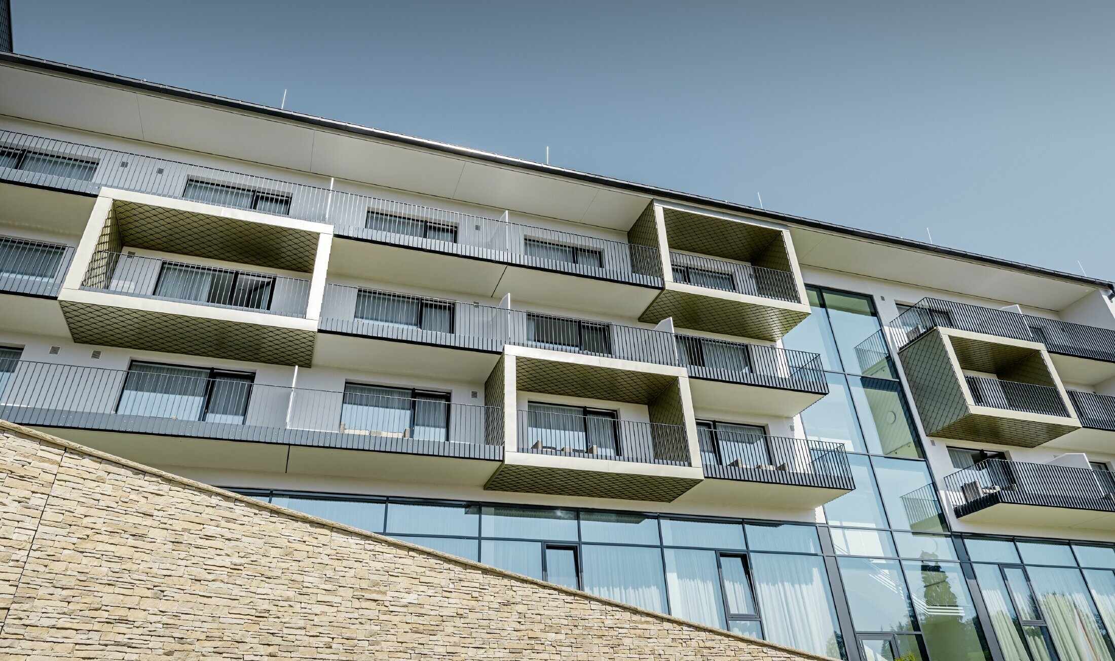 Obložení balkonu hotelu Edita v Scheideggu fasádními šablonami 20 x 20 PREFA ve světlém bronzu