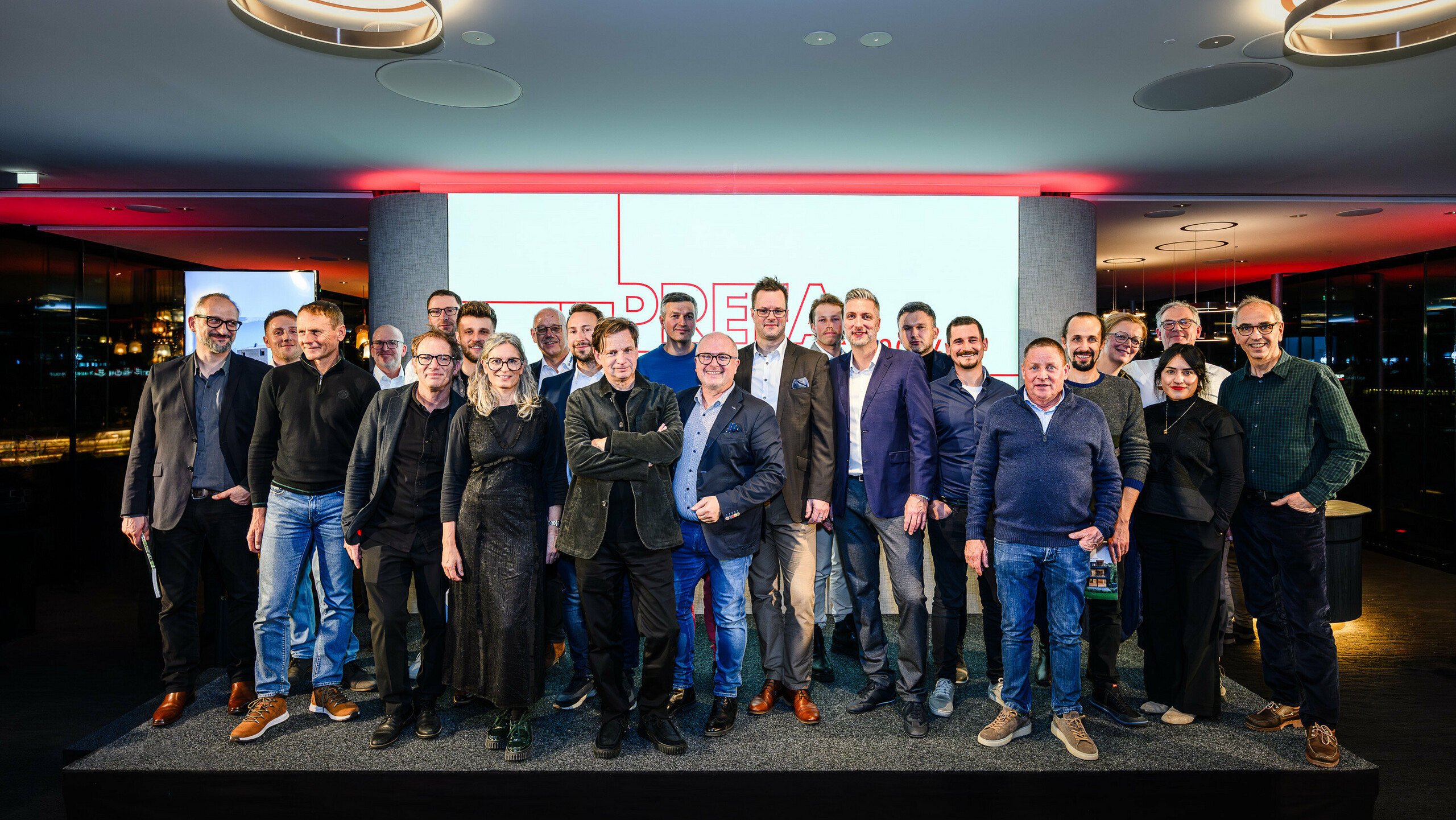 Společná fotografie architektů, projektantů a dodavatelů na pódiu prezentace PREFARENZEN 2026 v k47.wien – silného symbolu komunity, kreativity a progresivní architektury. Před osvětleným logem PREFARENZEN stojí designéři stojící za působivými projekty s hliníkem PREFA. Scéna odráží hrdost, inovaci a spolupráci. Produkty PREFA nabízejí trvanlivá, povětrnostně odolná řešení s estetickým vzhledem – ideální pro moderní architektonické koncepty. Inspirativní večer plný výměny názorů, vizí a silných partnerství.