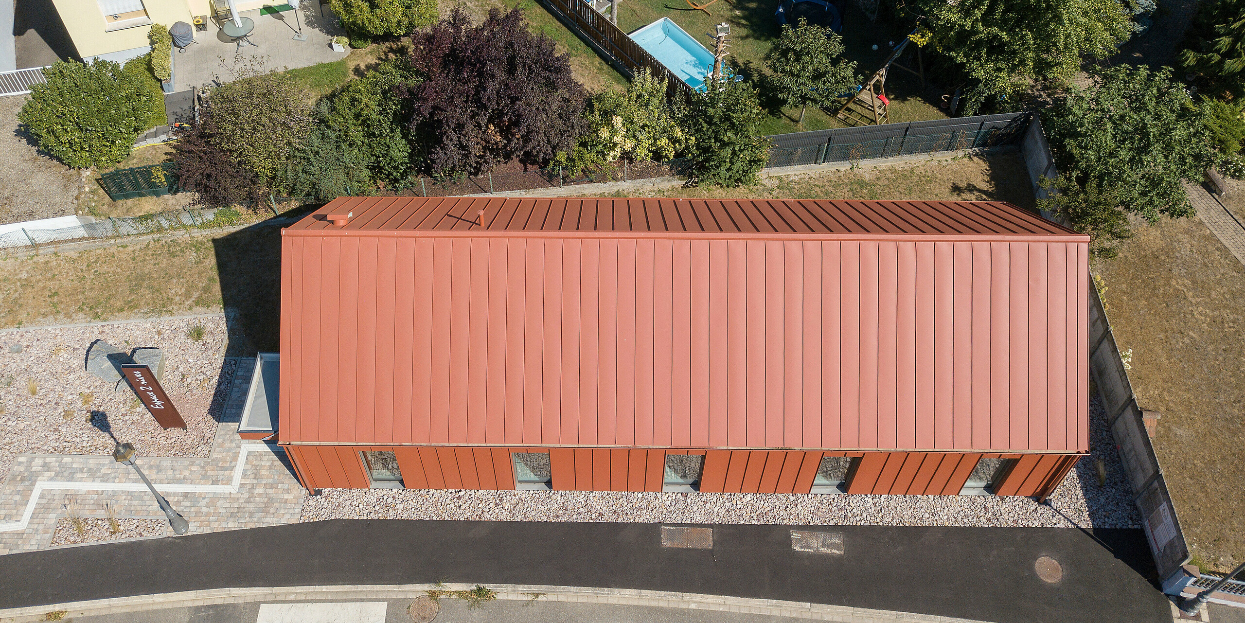 Sedlová střecha fary v cihlově červené barvě z PREFALZ