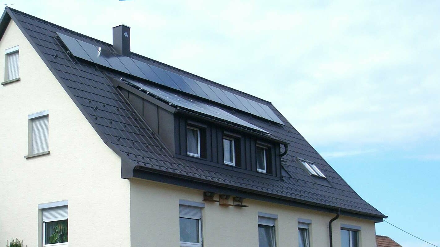 čerstvě sanovaná střecha s PREFA falcovanými střešními taškami v antracitové barvě, vikýř byl obložen plechem Prefalz; na střeše je fotovoltaický systém.