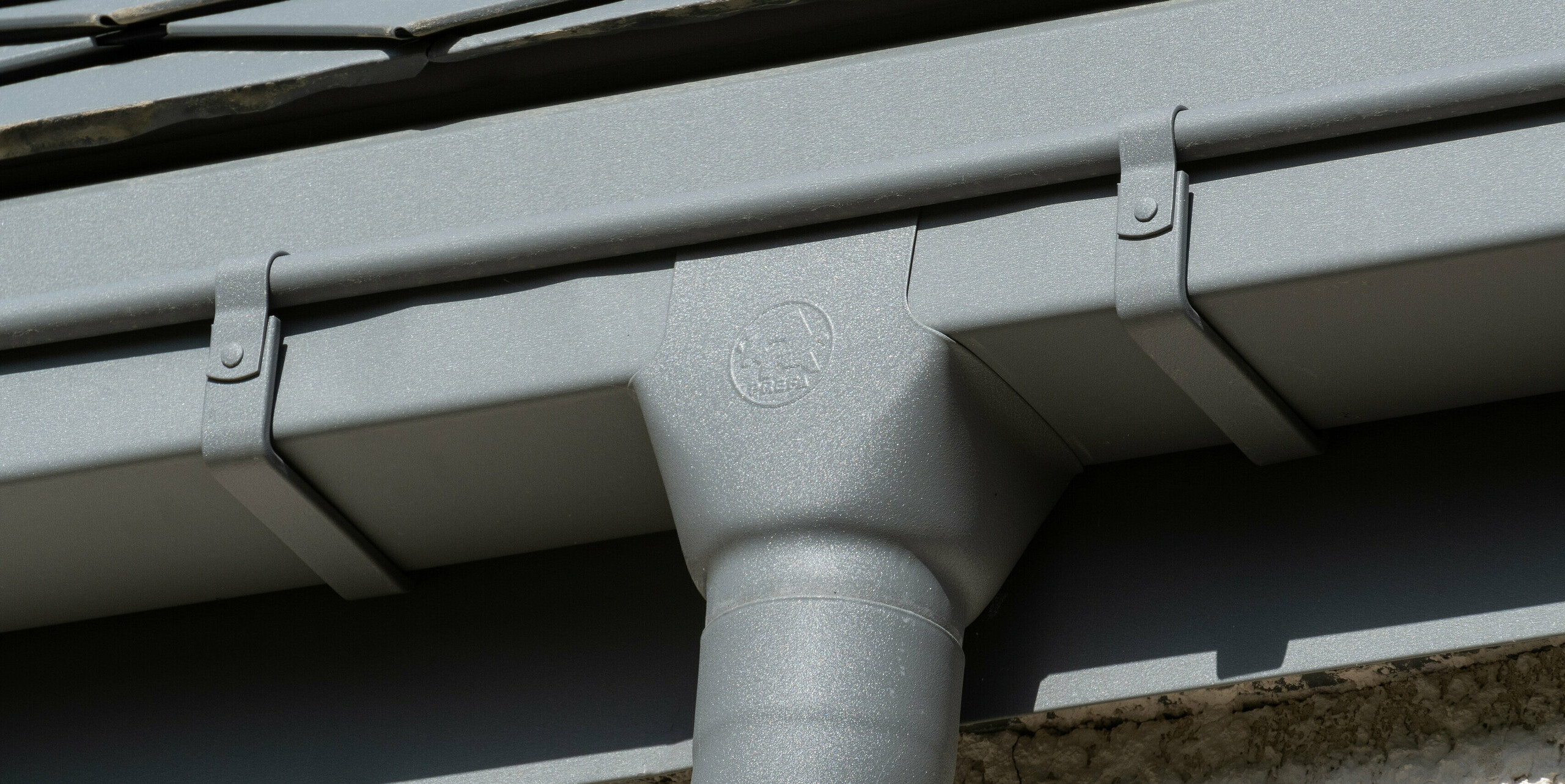 Detail odvodňovacího systému (hranatého žlabu a kruhového svodu) od PREFA