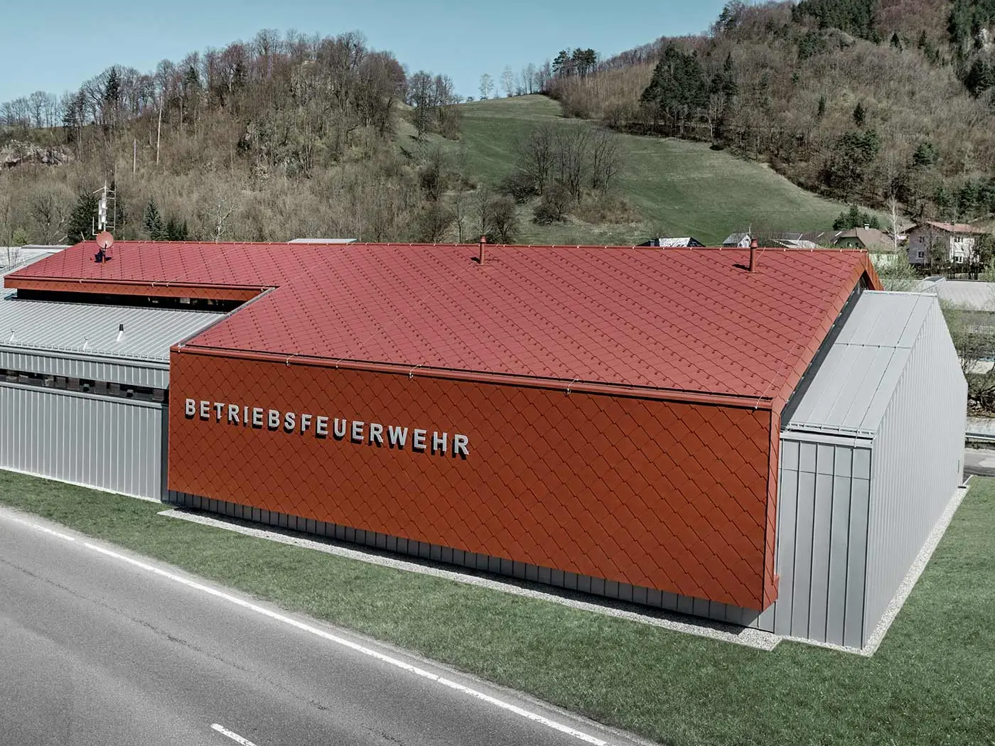 Nová zbrojnice hasičského sboru firmy PREFA a Neuman Aluminium byla opláštěna novou střešní a fasádní šablonou 44 × 44 v barvě tmavě červená P.10 a hliníkovým plechem Prefalz v provedení stříbrná metalíza.