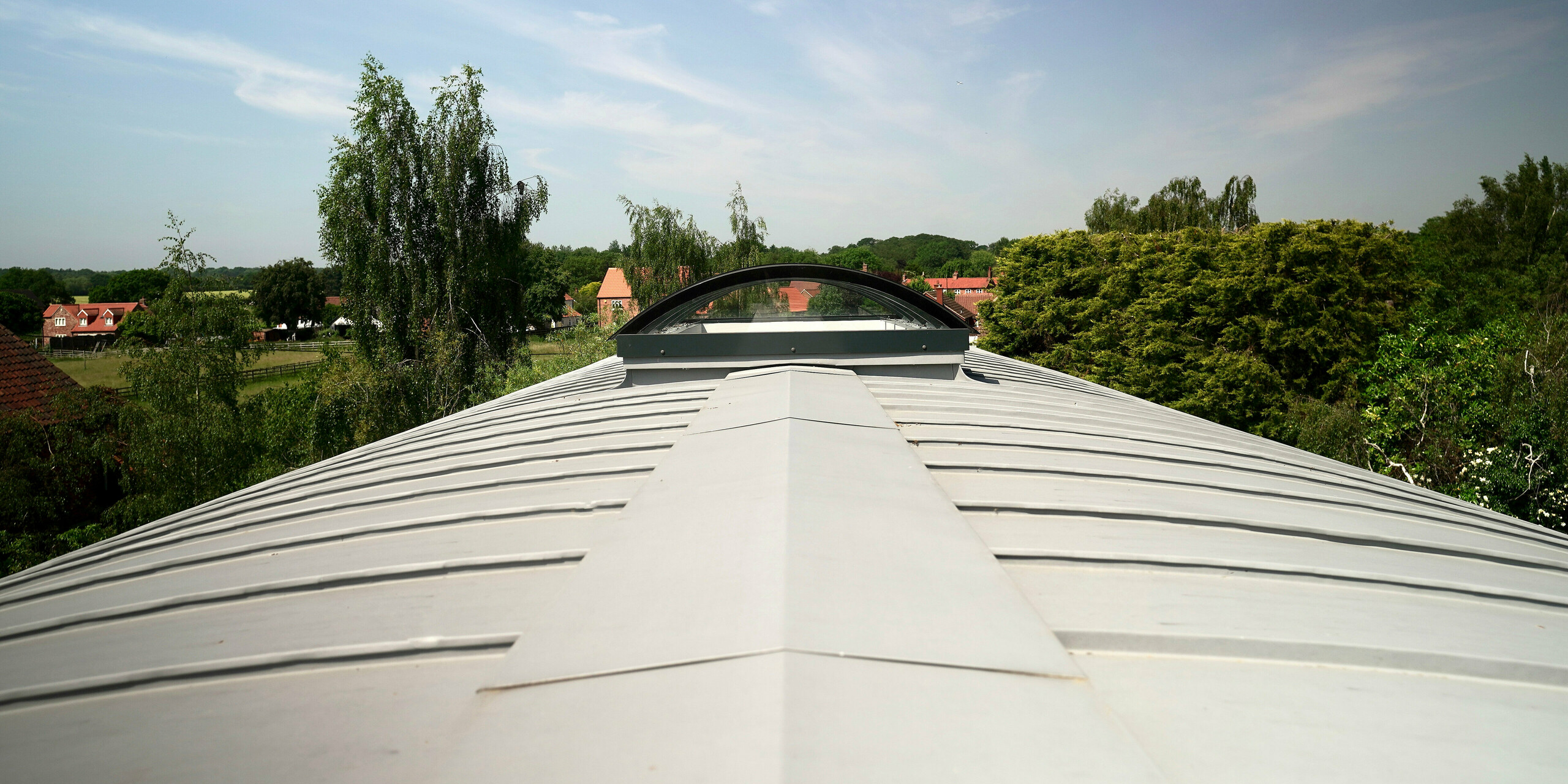 Detailní pohled na zaoblenou střechu pokrytou plechem PREFALZ v barvě patina šedá