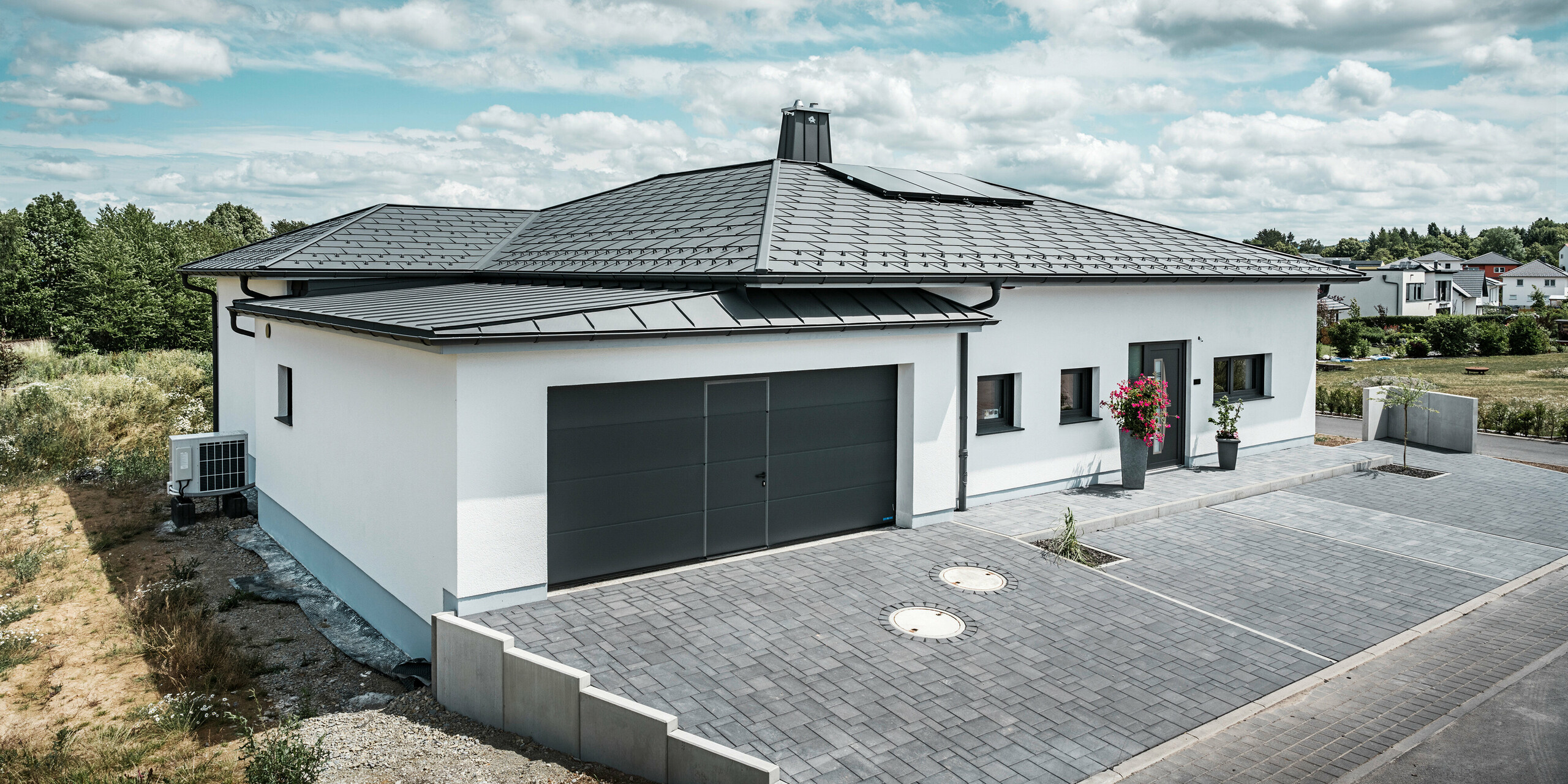 Střešní panel R.16, PREFALZ, sněhové háky a půlkulatý žlab s kruhovým svodem v barvě P.10 tmavě šedé. To vše lze nalézt na střeše rodinného domu v Illmenau.