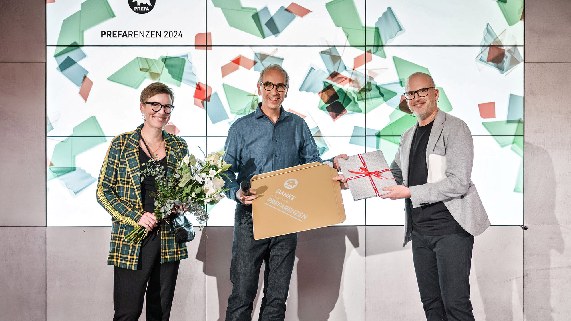 Fotografové Juliane Croce a Wolfgang Croce s mezinárodním marketingovým manažerem Jürgenem Jungmairem předali dárek před prezentační plochou.