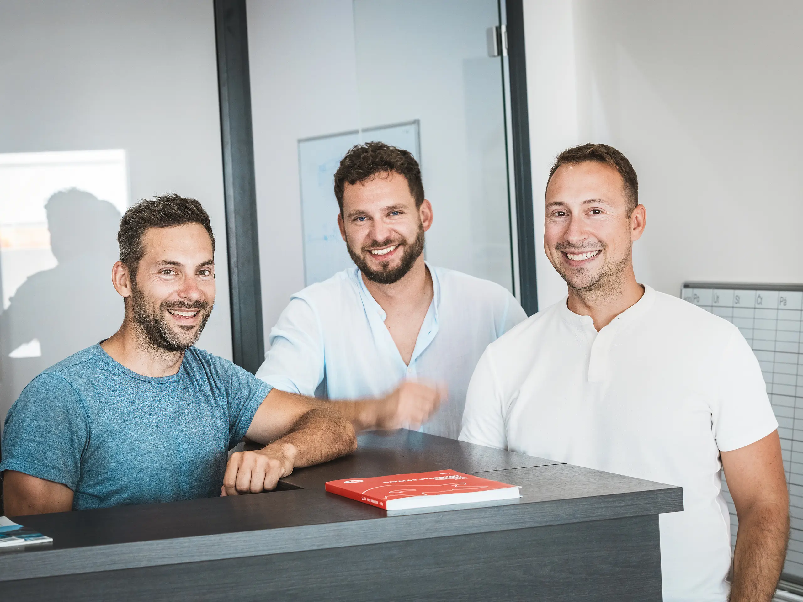U recepčního pultu v moderní kanceláři bratři Juraj a Peter Pekárovi spolu s Tomášem Filem ze střešní firmy Prvá Strechárska poskytují autentický vhled do projektového týmu, který stojí za městskou čtvrtí Vydrica v Bratislavě. Jako klíčoví hráči realizovali komplexní střešní úpravy s použitím hliníkových střešních šindelů PREFA, které přesvědčují svou přesností, trvanlivostí a odolností vůči povětrnostním vlivům a významně přispívají k vysoce kvalitnímu a udržitelnému plášti budovy.