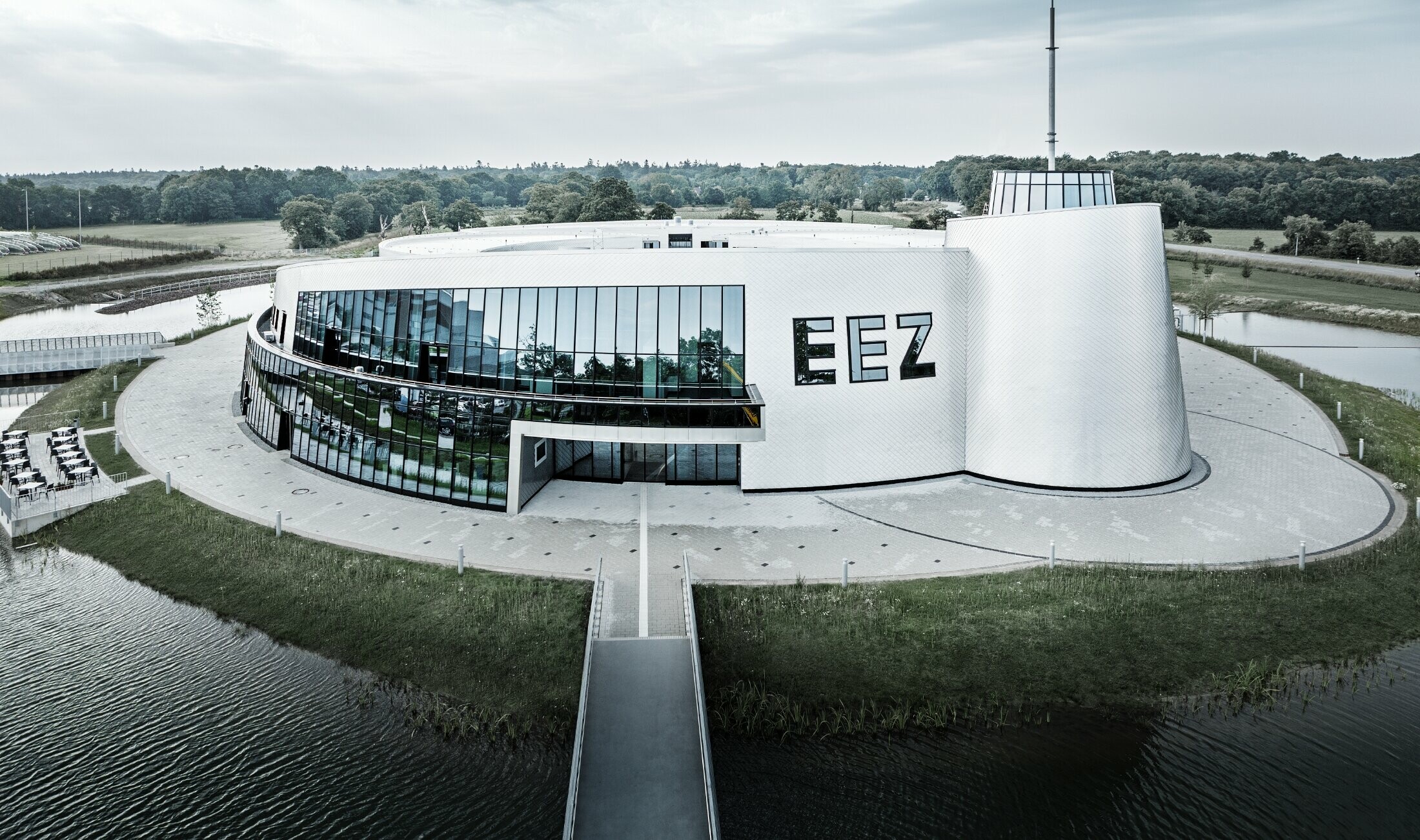 V Energy Experience Centru (EEZ) v Aurichu bylo mnoho zaoblených částí budovy obloženo fasádní šablonou PREFA 20 × 20 v přírodním provedení.