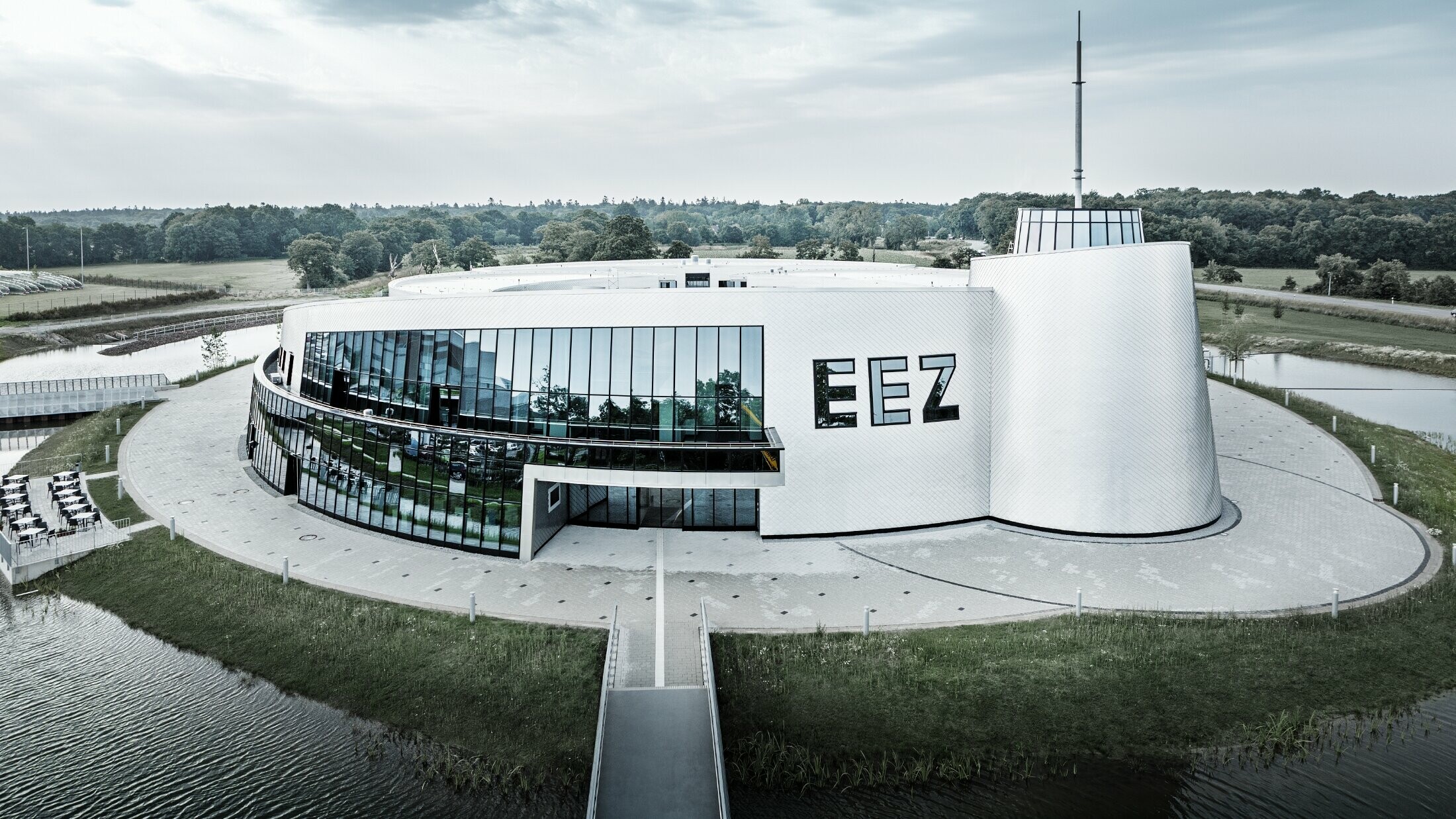 V Energy Experience Centru (EEZ) v Aurichu bylo mnoho zaoblených částí budovy obloženo fasádní šablonou PREFA 20 × 20 v přírodním provedení.