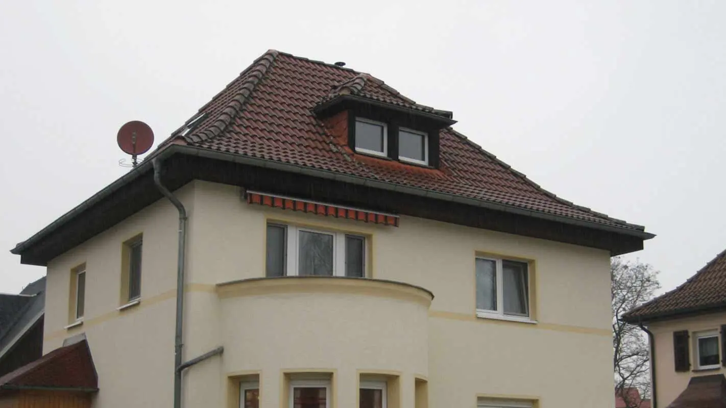 Valbová střecha s vikýřem před sanací za použití PREFA falcovaných střešních šindelů 