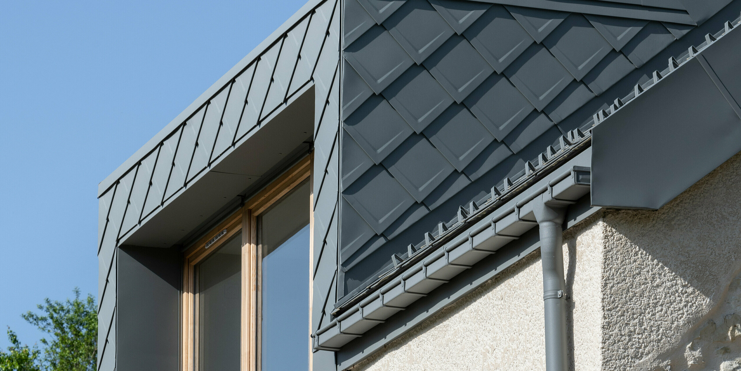 PREFA hliníková střecha z falcovaných šablon 29x29 v barvě P.10 světle šedé na prázdninovém domě v Engins u Grenoblu