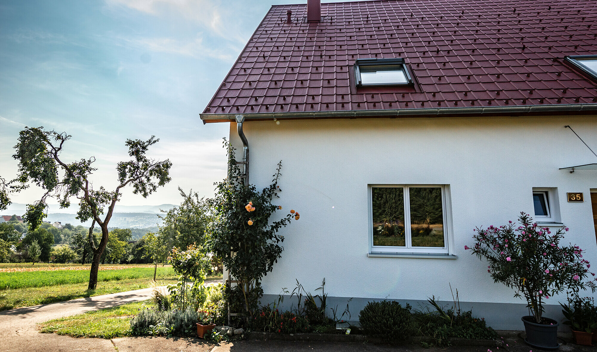 Chalupa na venkově s nově zrekonstruovanou střechou z falcované tašky v barvě P.10 tmavě červené, světlíkem a oplechovaným komínem. 