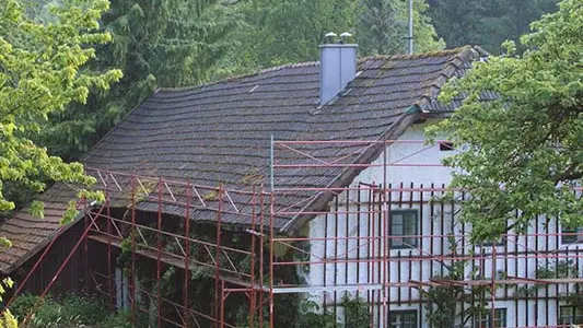 Stará střecha statku Wiesenhaus před sanací PREFA falcovanými střešními šindeli, s lešením