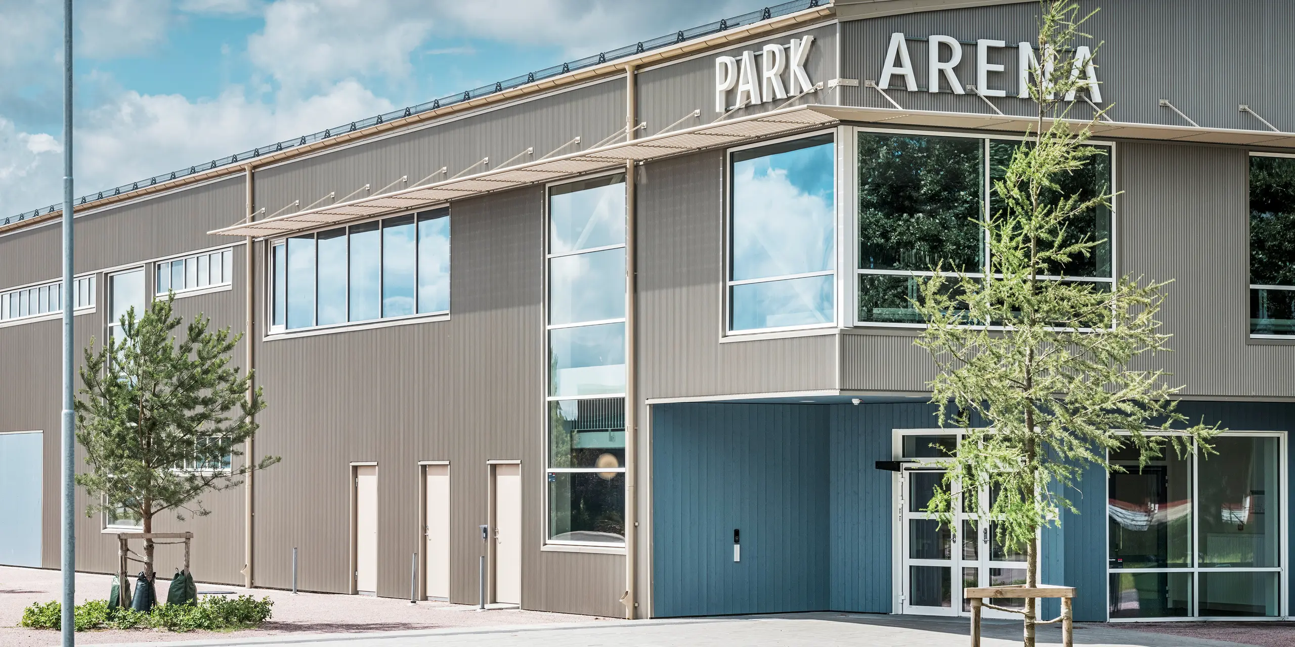 Vstupní prostor Park Areny ve Värnamo ve Švédsku s moderním designem fasády v podobě pilového Zackenprofilu PREFA v bronzu. Robustní a povětrnostním vlivům odolná hliníková fasáda dodává sportovní hale o rozloze 3 300 m² elegantní a výrazný vzhled. Pilový profil vytváří fascinující světelné a stínové efekty, které podtrhují architektonické řešení arény.