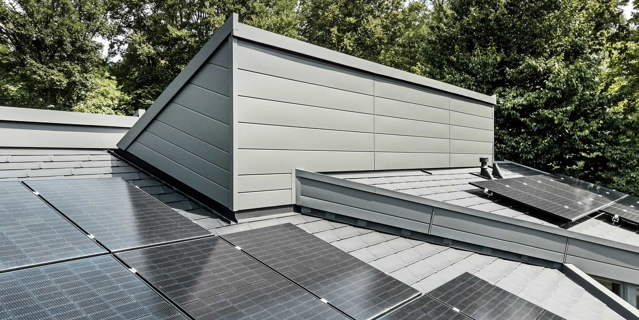 Solární panely na střeše domu s fasádními lamelami Siding a falcovanými šindeli DS.19