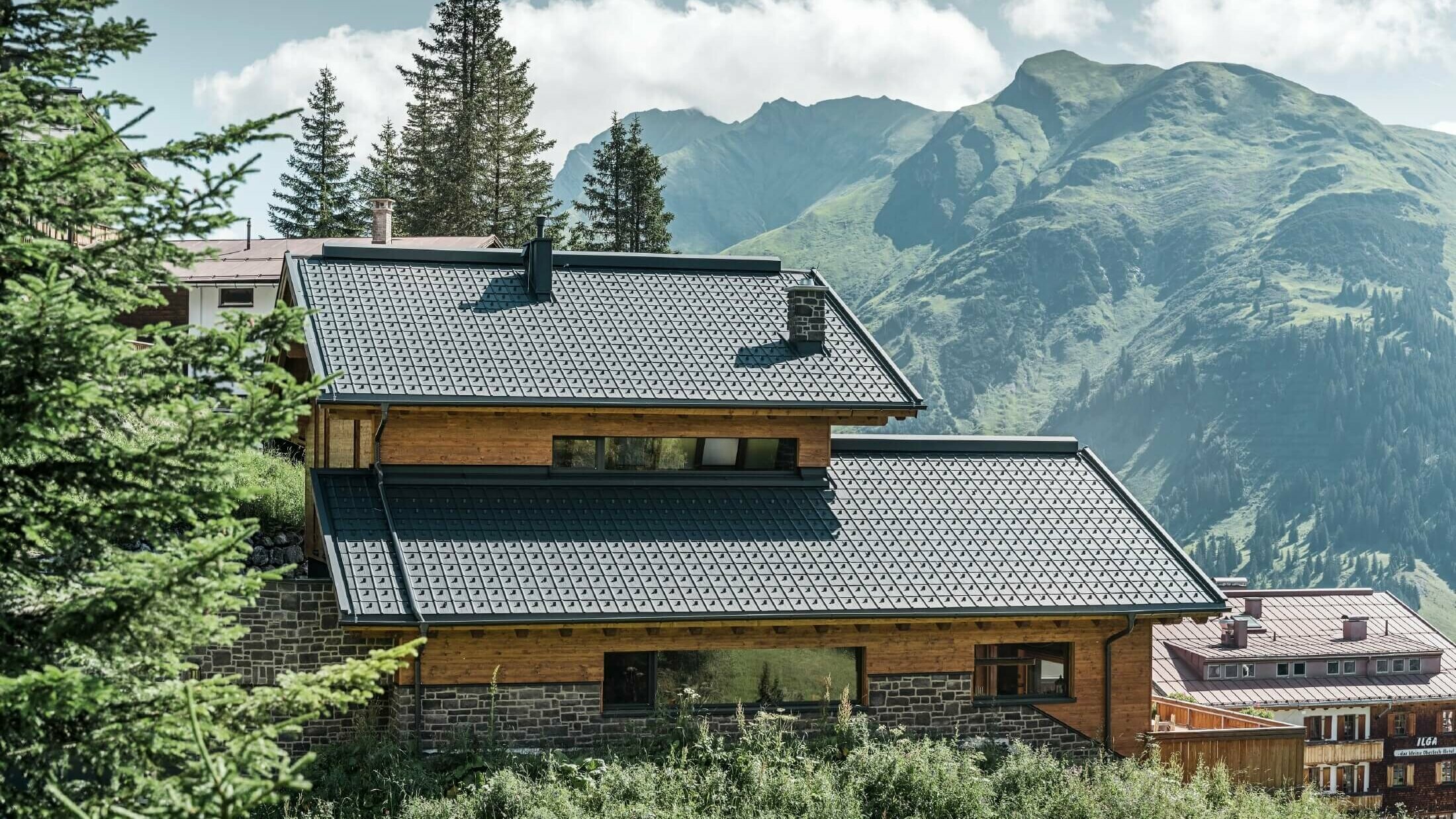 Dům v alpském prostředí se střešní krytinou falcovaná taška v antracitové barvě