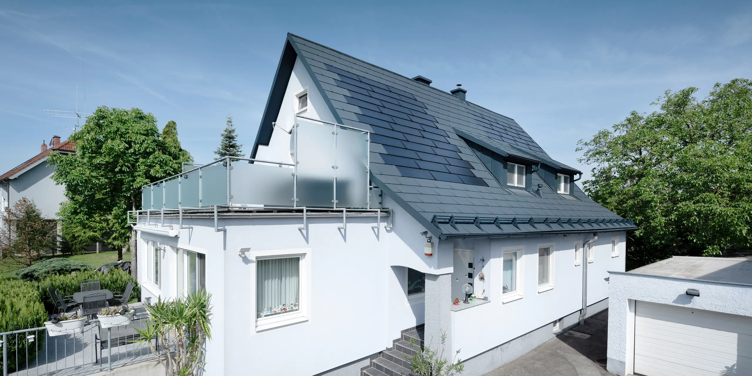 Rekonstrukce střechy rodinného domu v Leondingu pomocí integrovaných solárních panelů SDP od PREFA v antracitové barvě. Tyto inovativní solární panely nabízejí udržitelný a energeticky účinný způsob výroby elektřiny a generují výkon 10,6 kWp. Moderní, trvanlivé a povětrnostním vlivům odolné materiály PREFA přispívají k estetické a funkční střešní konstrukci, která splňuje nejnovější standardy udržitelné výstavby.