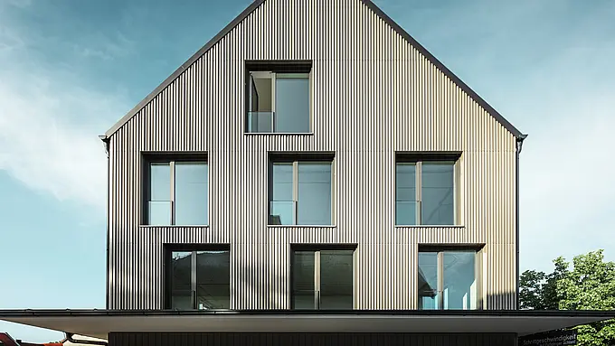 Na obrázku je moderní budova ve Feldkirchu, kterou navrhl architekt Stefan Heigl. Fasáda je obložena Prefalz v barvě bronzu, sedlová střecha je pokryta Prefalz v černo-šedé. Velká, obdélníková okna poskytují dostatek přirozeného světla uvnitř. Budova kombinuje vysoce kvalitní materiály a elegantní architekturu, která je funkční i esteticky příjemná. Tato moderní konstrukce a použití materiálů Prefalz dodávají budově současný a stylový vzhled.