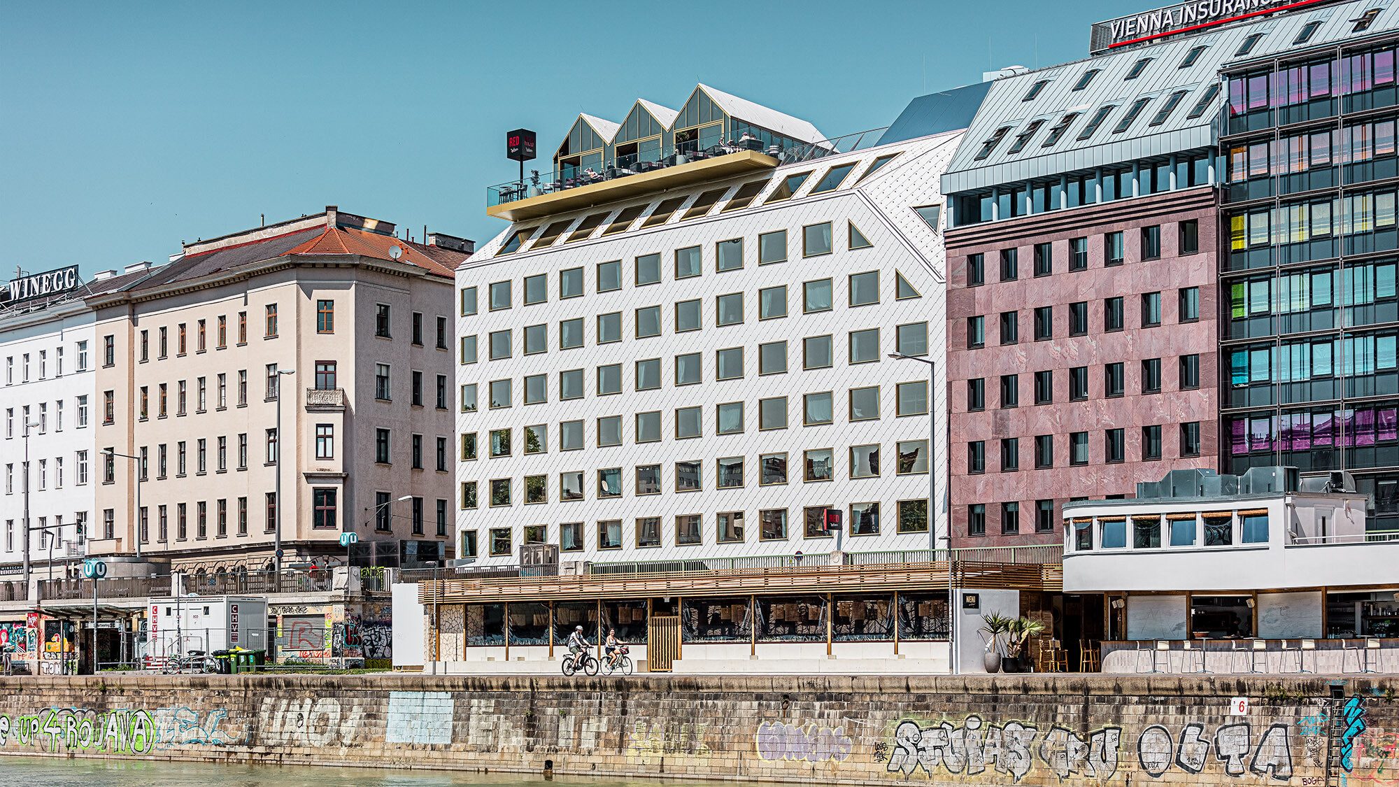 Hotel z bočního pohledu včetně zastavěného okolí, přímo před ním se rozprostírá Dunajský kanál.