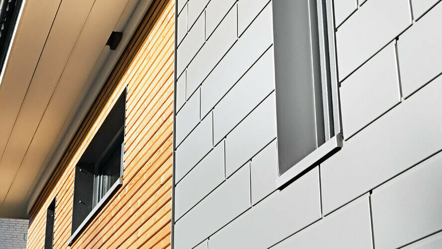 Kombination von Aluminiumg - PREFA Siding in Graualuminium - mit einer Holzfassade. Horizontale Verlegung, versetzte Fugen.